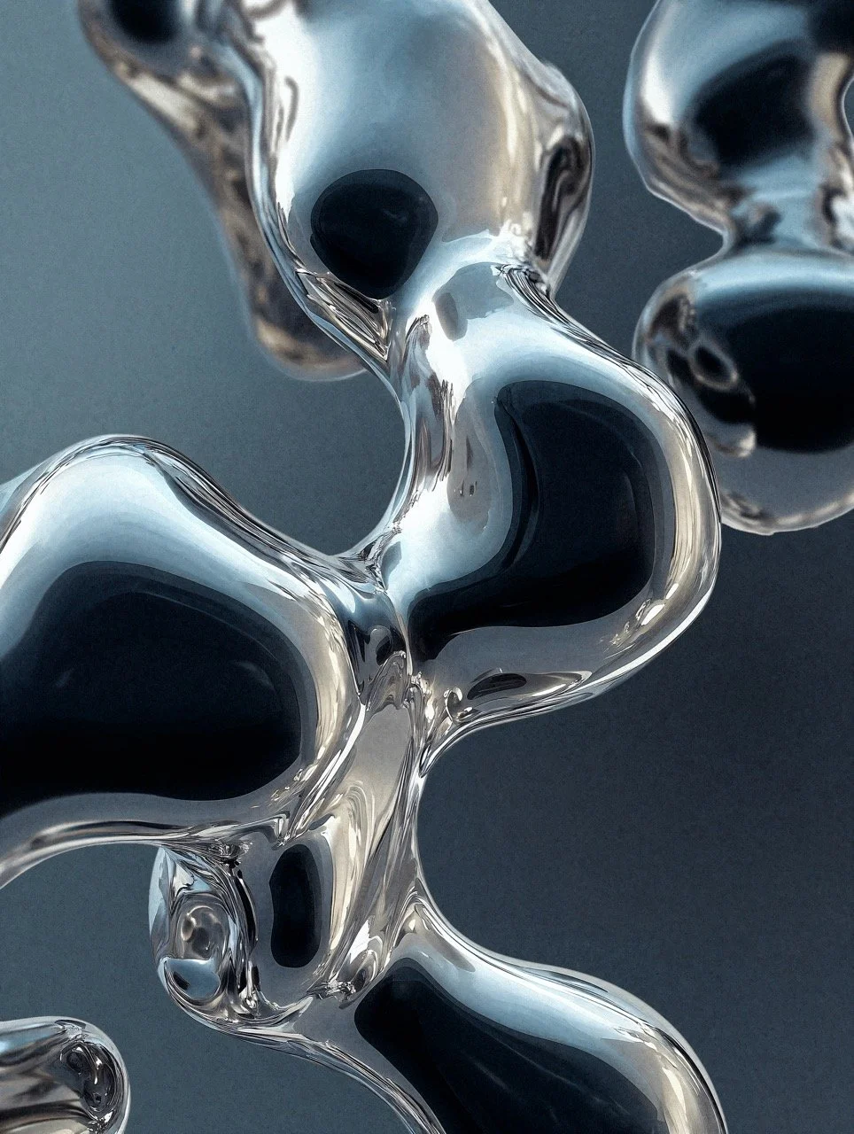 Close-up of abstract metallic sculptures with smooth, flowing shapes and reflective surfaces against a dark background.