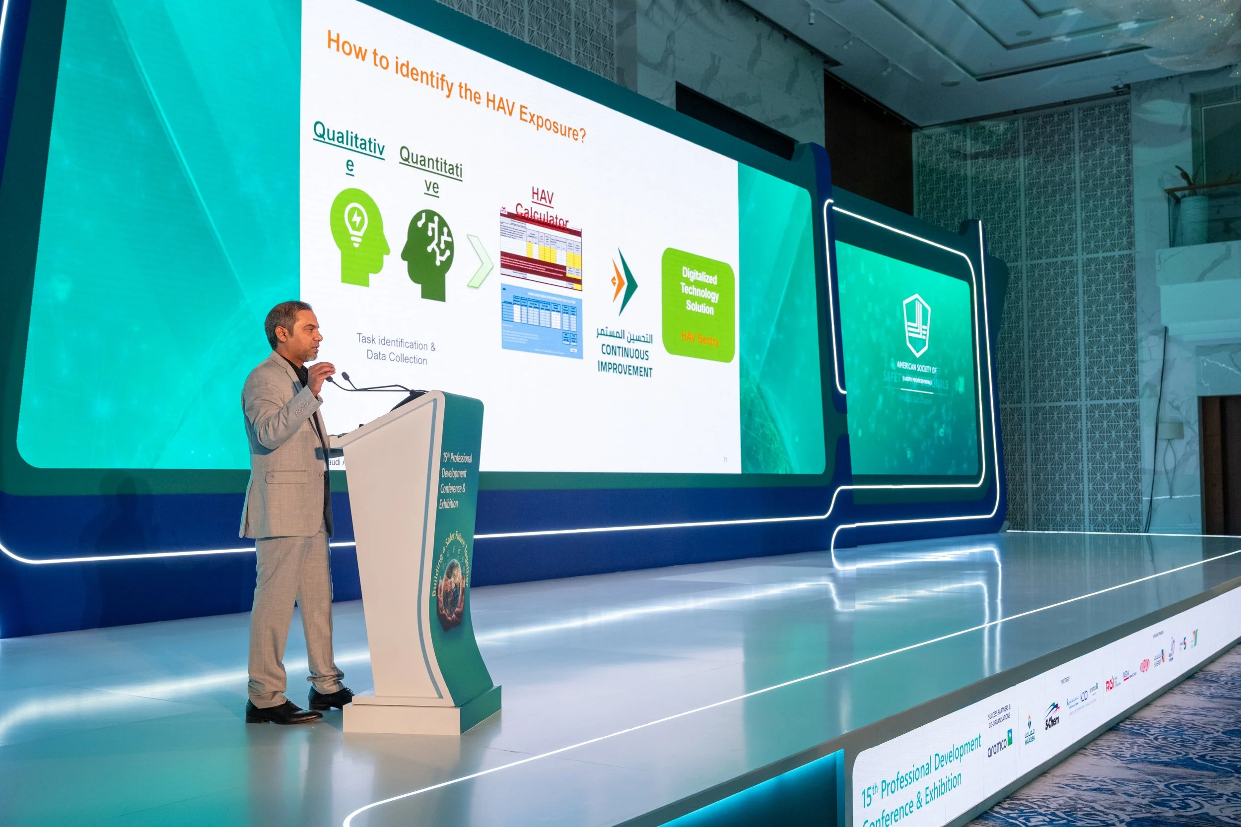 A man standing on stage at a conference, 