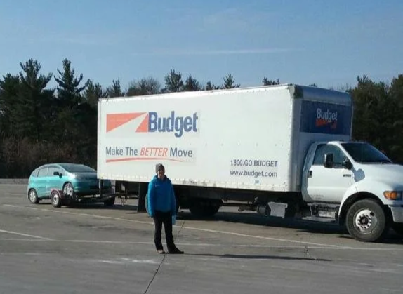 moving truck with towed car behind
