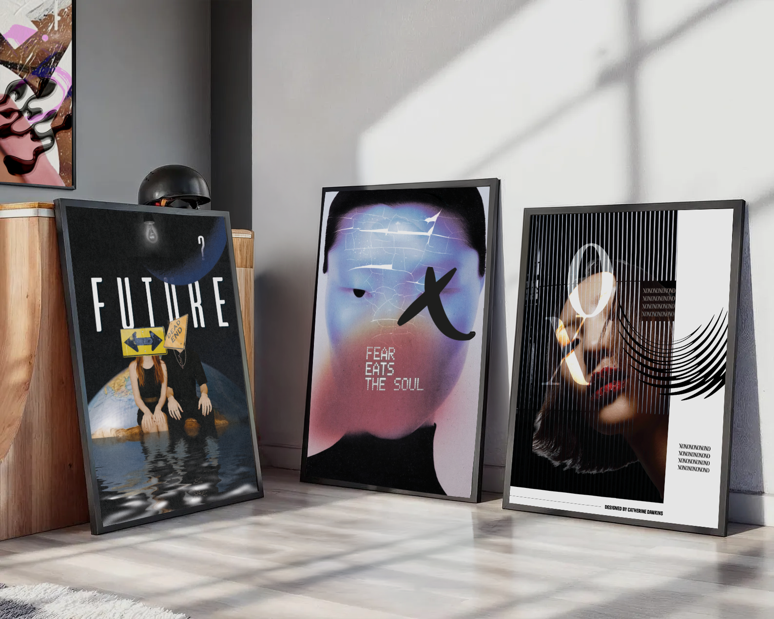 Three framed art posters leaning against a wall in a room. The left poster displays the word 'FUTURE' with a woman sitting on a reflective water surface, wearing a black dress, with a caution sign covering her face. The middle poster features a stylized face with a crackled texture, with the words 'FEAR EATS THE SOUL' below it and a large black 'X' across the face. The right poster shows a woman's face partially obscured by black vertical lines, with an illuminated circle around her eye and a curved pattern on the right side.