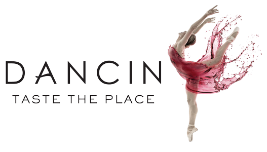 A dancer in a pink tutu performing a handstand over stylized text that reads 'Dance is the place'.