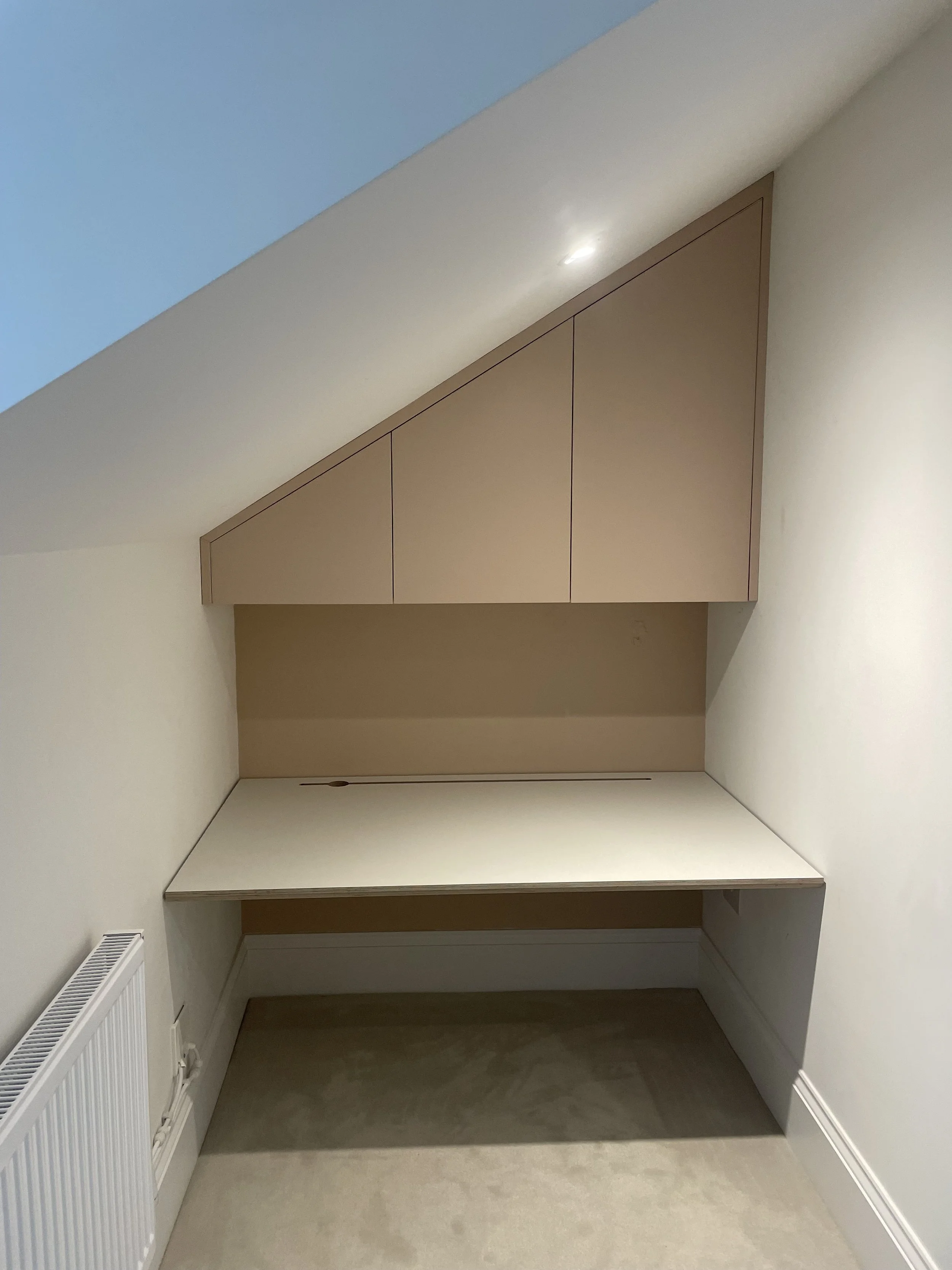 Here we used this section of spare space to form a little office space for this client. The computer desk was laminated with a laminate of the clients choice and the units were sprayed in the workshop in a peach colour adding contrast to the light gr