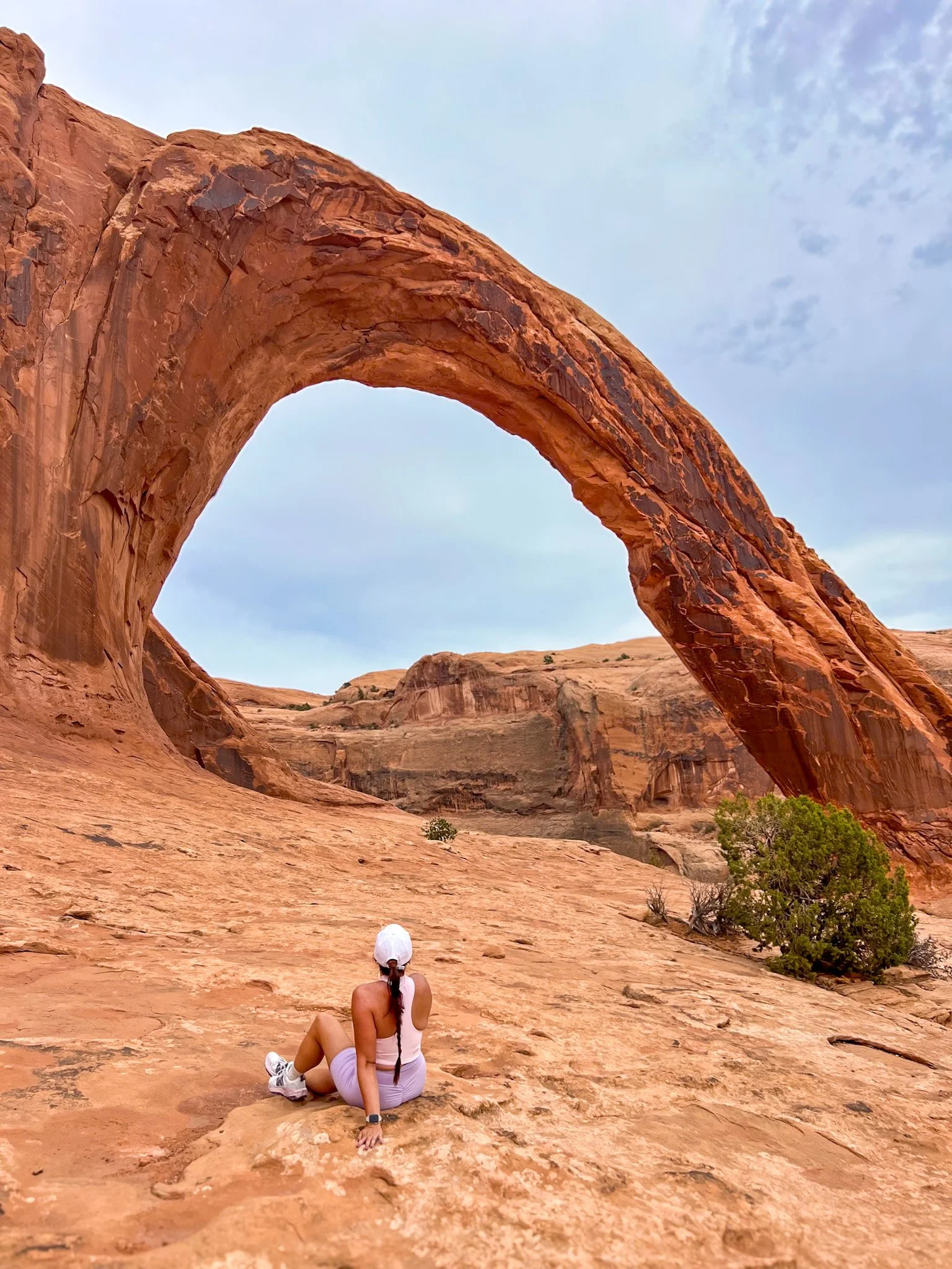 Corona Arch towering over hikers on the top arches in Moab list