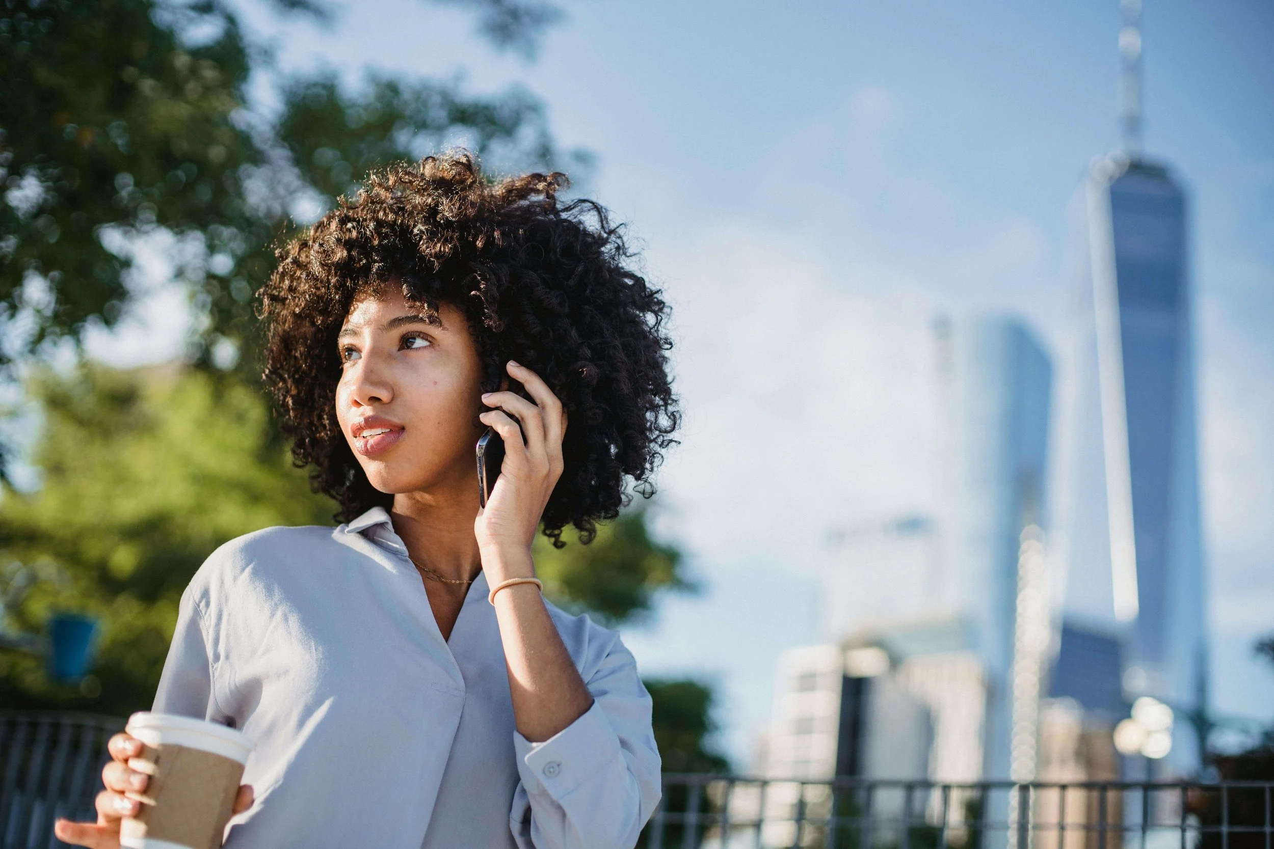 Woman walking in New York City talking on the phone in professional attire, illustrating adjustment and growth supported by Manhattan life transition counseling.