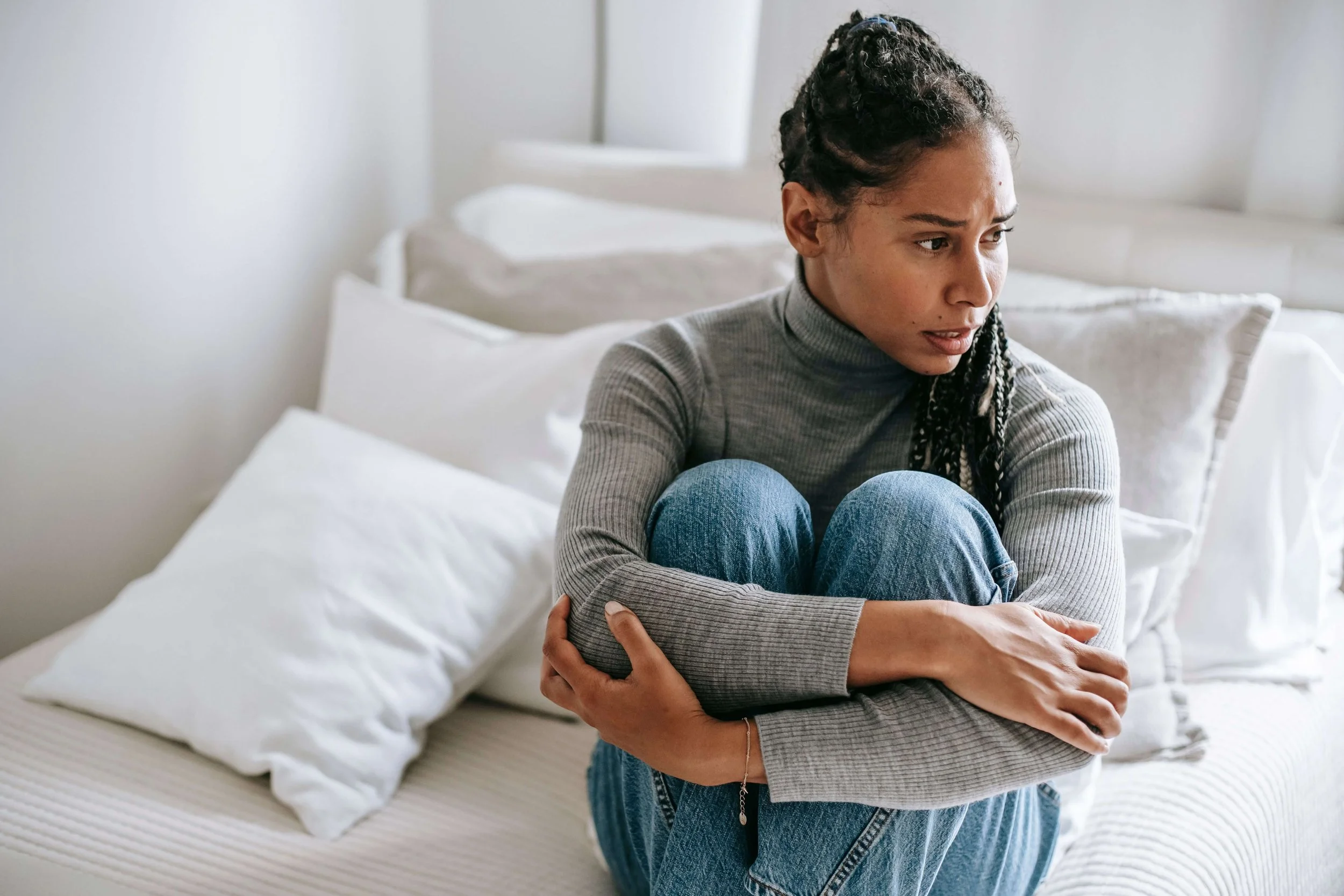 Anxious woman reflecting on self-doubt and high expectations that may be explored through perfectionism therapy in New York.