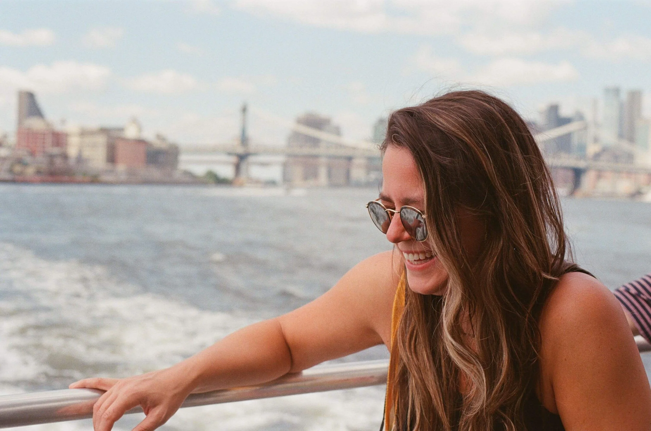 Woman wearing sunglasses and smiling outdoors in Manhattan, symbolizing confidence, emotional freedom, and growth supported through trauma therapy for young adults in Manhattan.