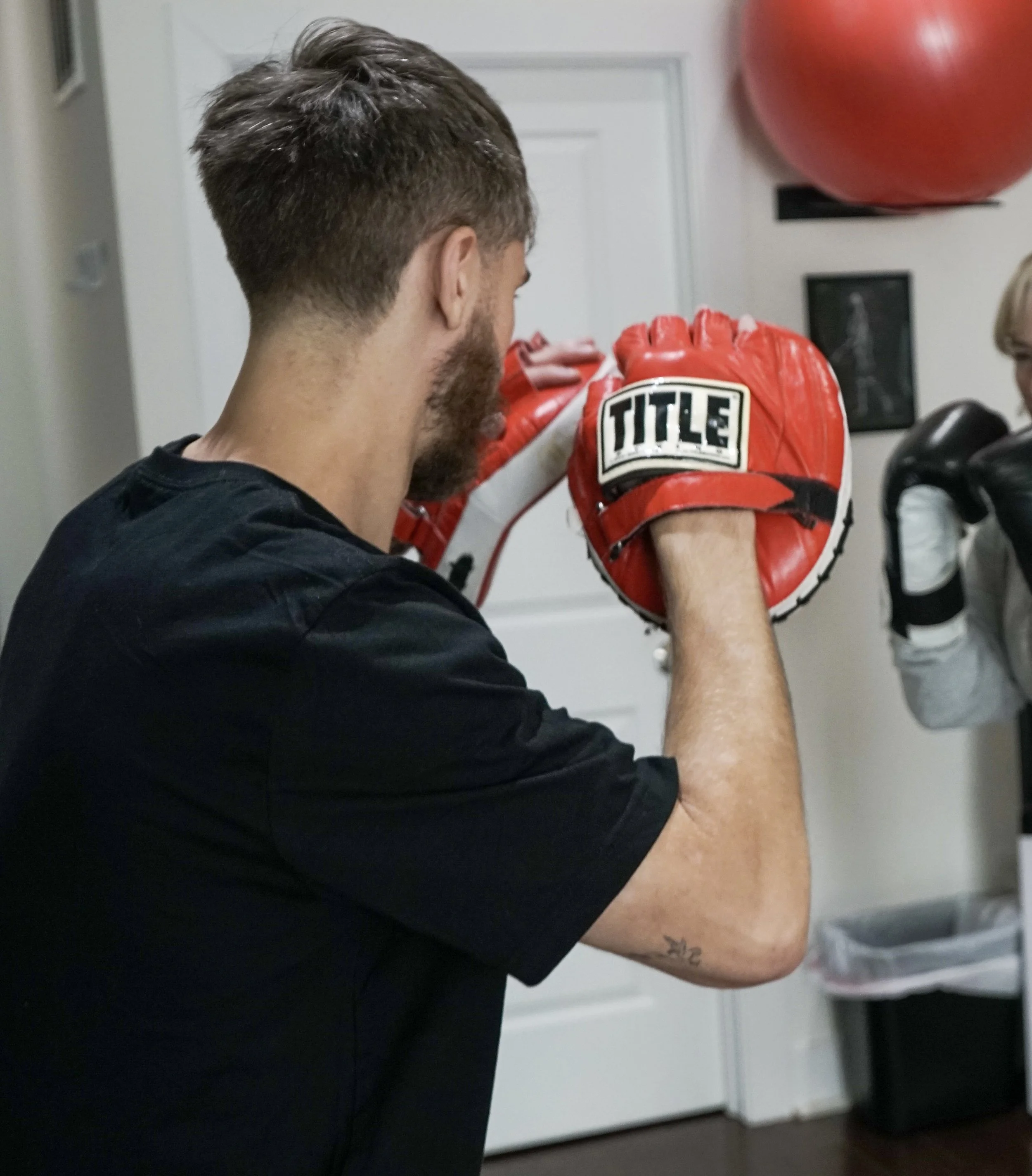 Coach Ben holds mitts during a private boxing lesson at Triad Wellness Philly.
