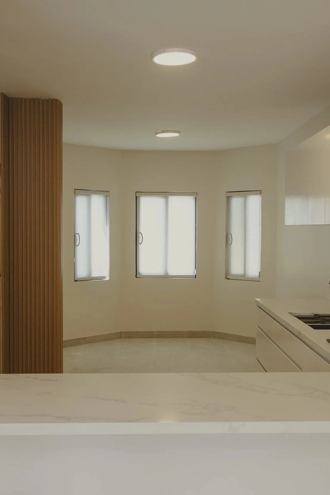 Interior de cocina moderna con ventanas y encimeras blancas