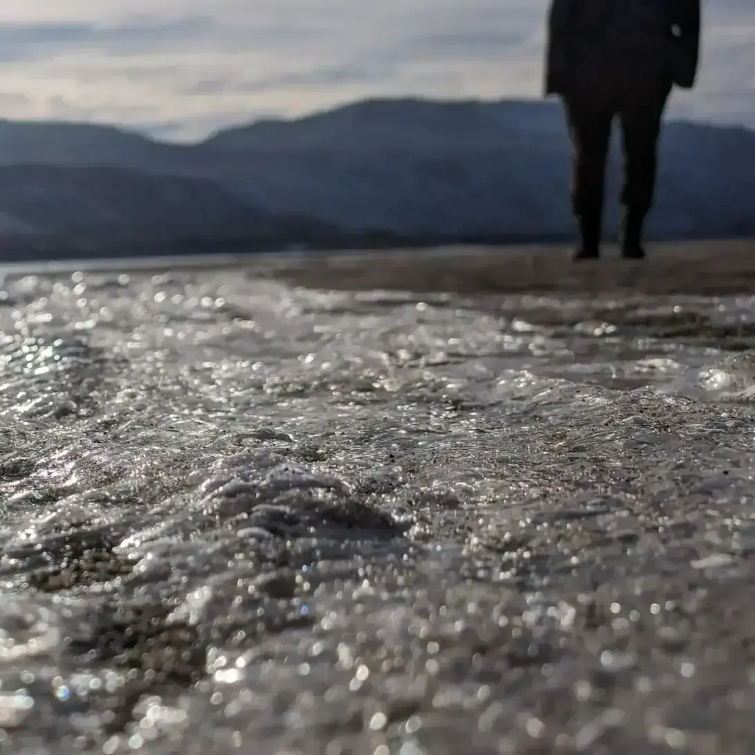 person standing in the distance next to a creek