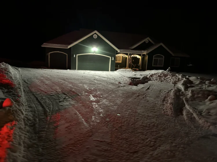 Bright green house with a plowed driveway