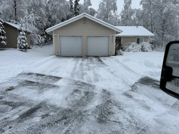 Cleared driveway at a tan house