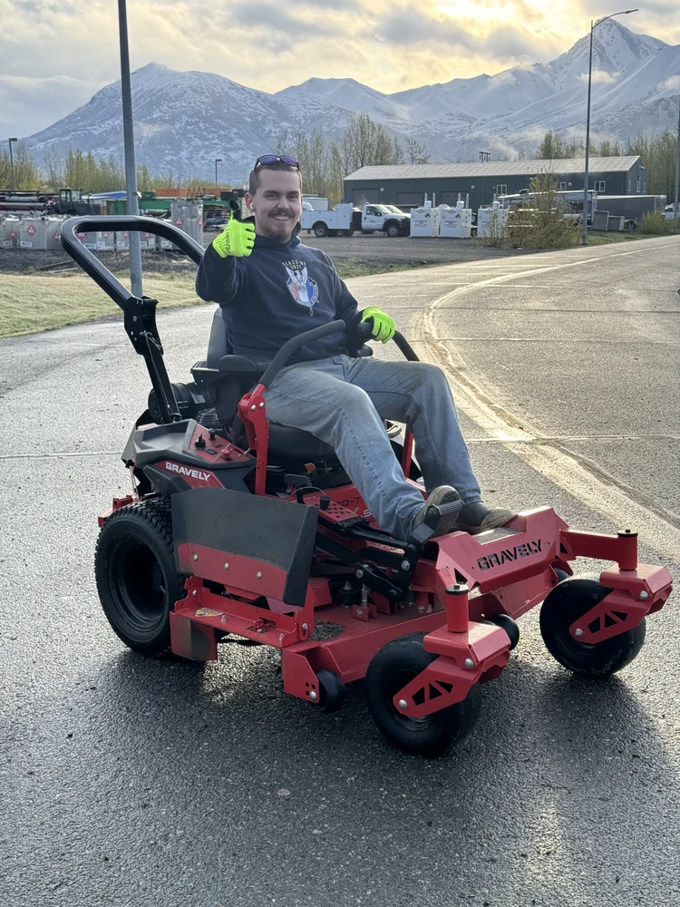 Crew member mowing a Palmer lawn