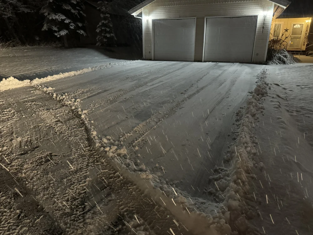 Garage and driveway plowed overnight with the lights on in Wasilla, Alaska