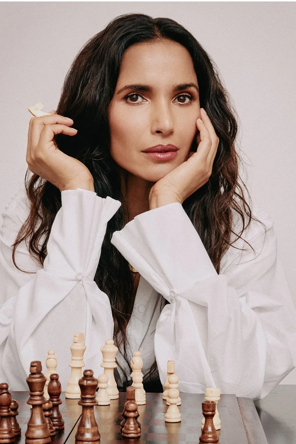 padma lakshmi for Marie claire styled in a crisp white cotton button down in front of a wooden chess board