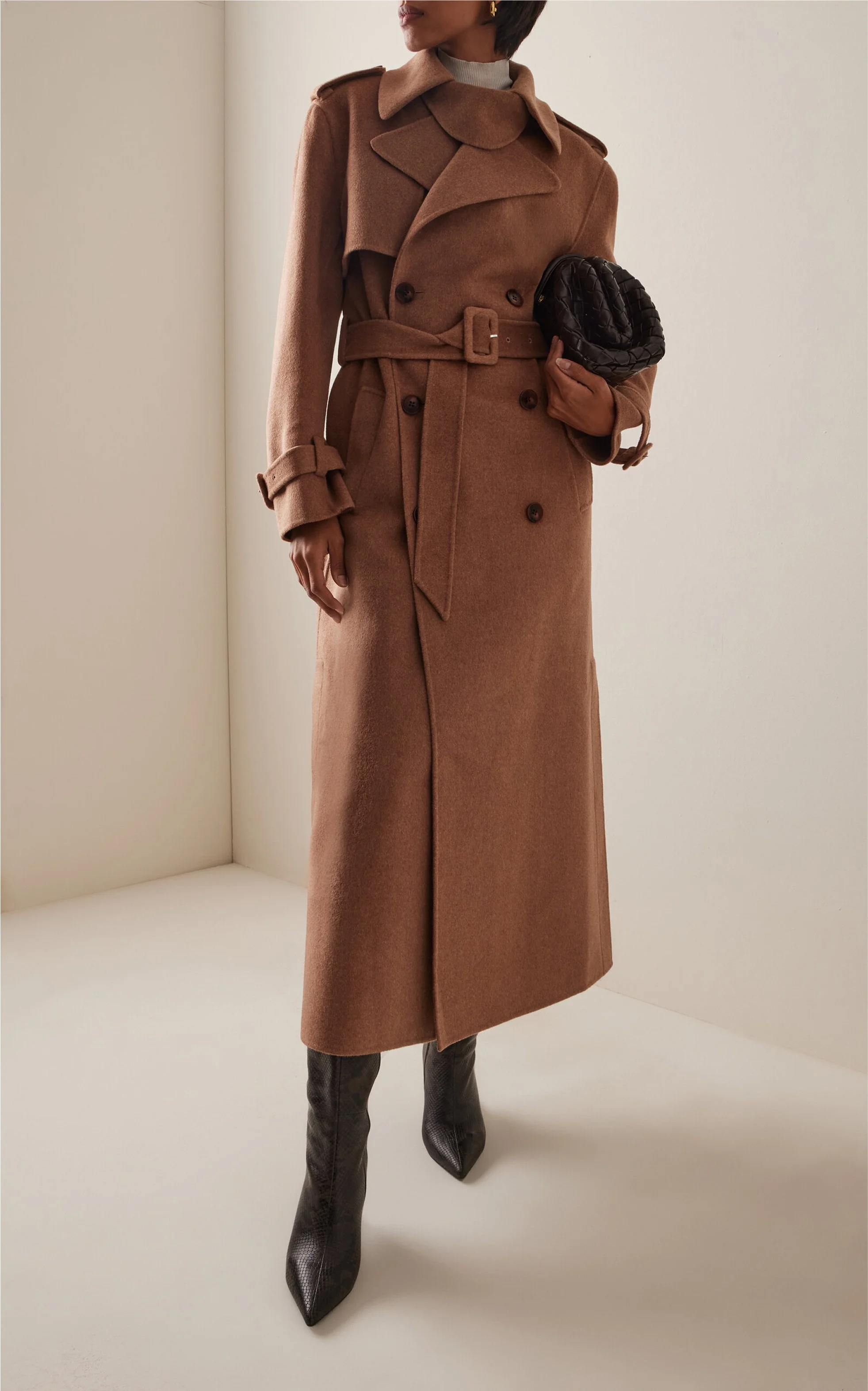 woman dressed in camel trench coat, styled with black pointed toe leather boots for moda operandi