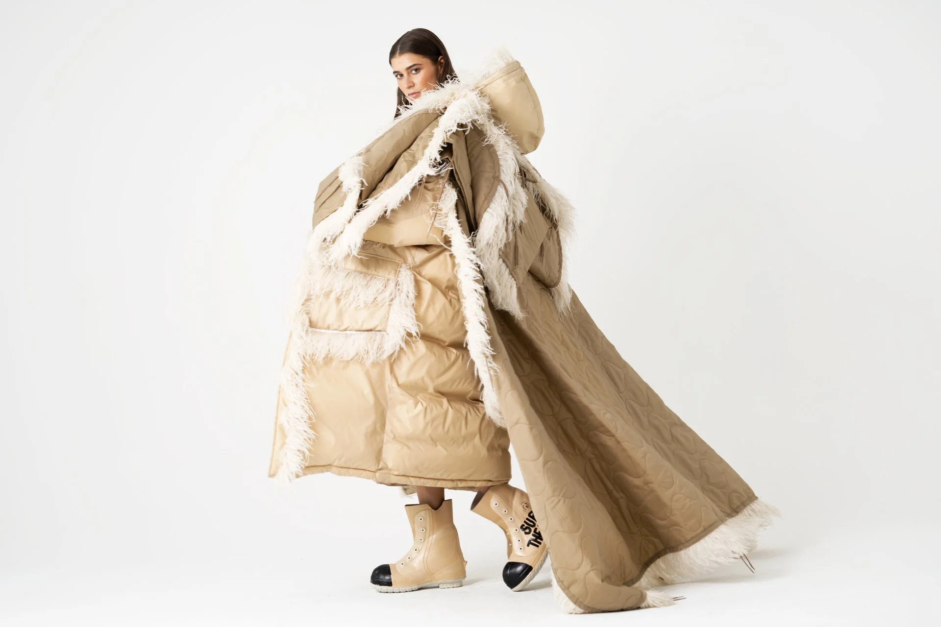 Model in oversized monochromatic fur lined parka and moon boots