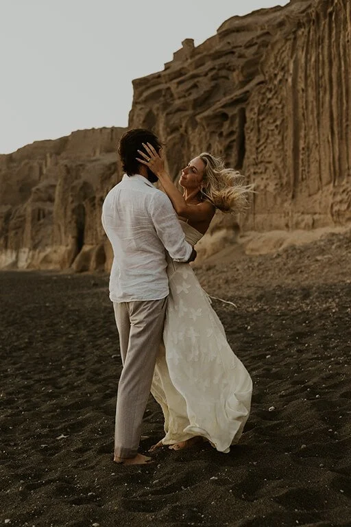 A couple embrace on a beach in Greece during their elopement