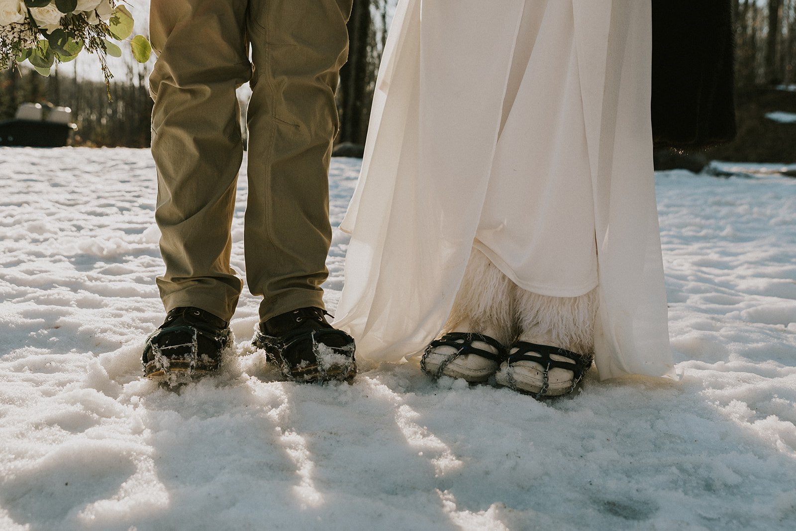 A bride and groom show off their snow boots during their winter elopement in Upper Michigan