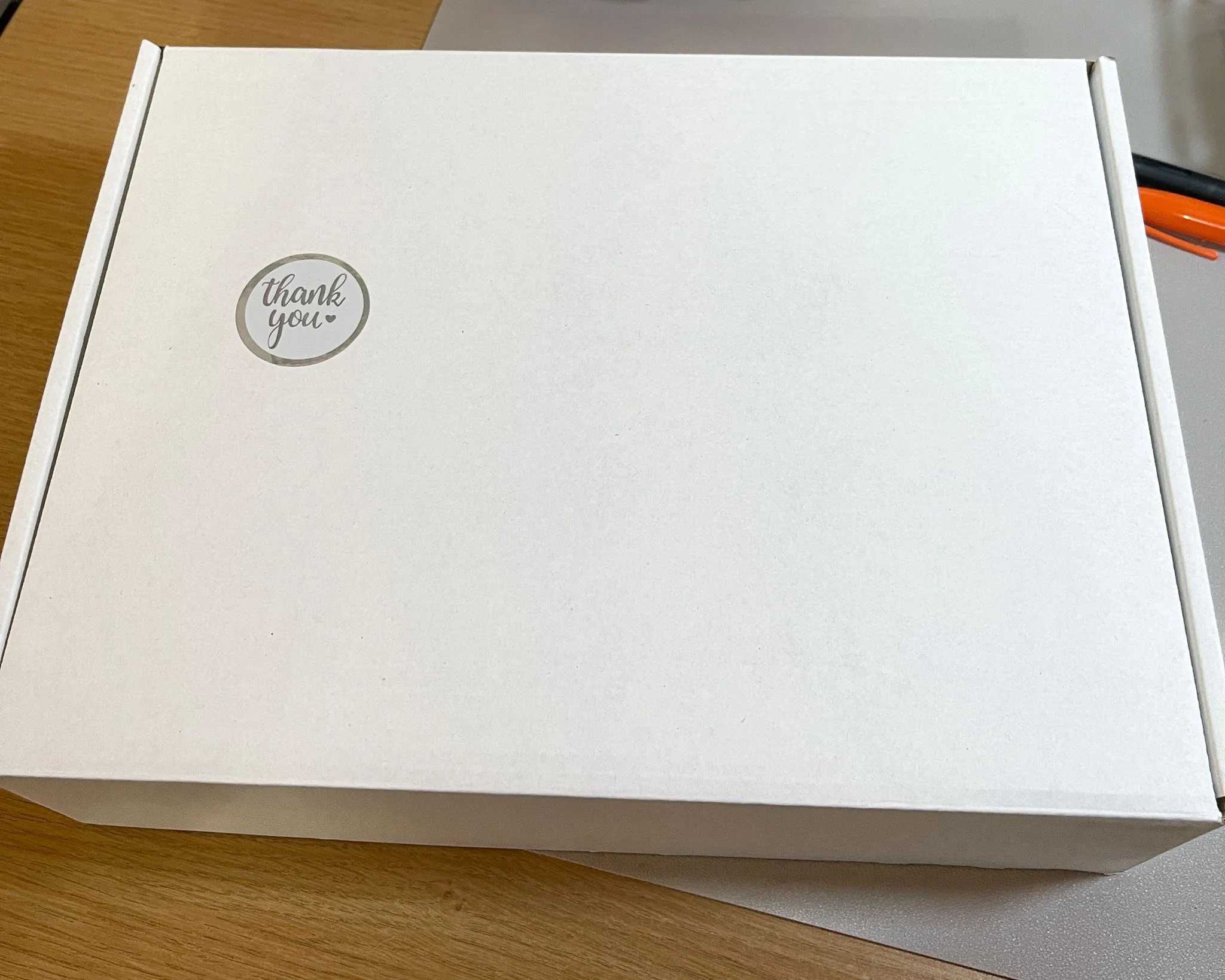 A photo of a white box with a thank you sticker