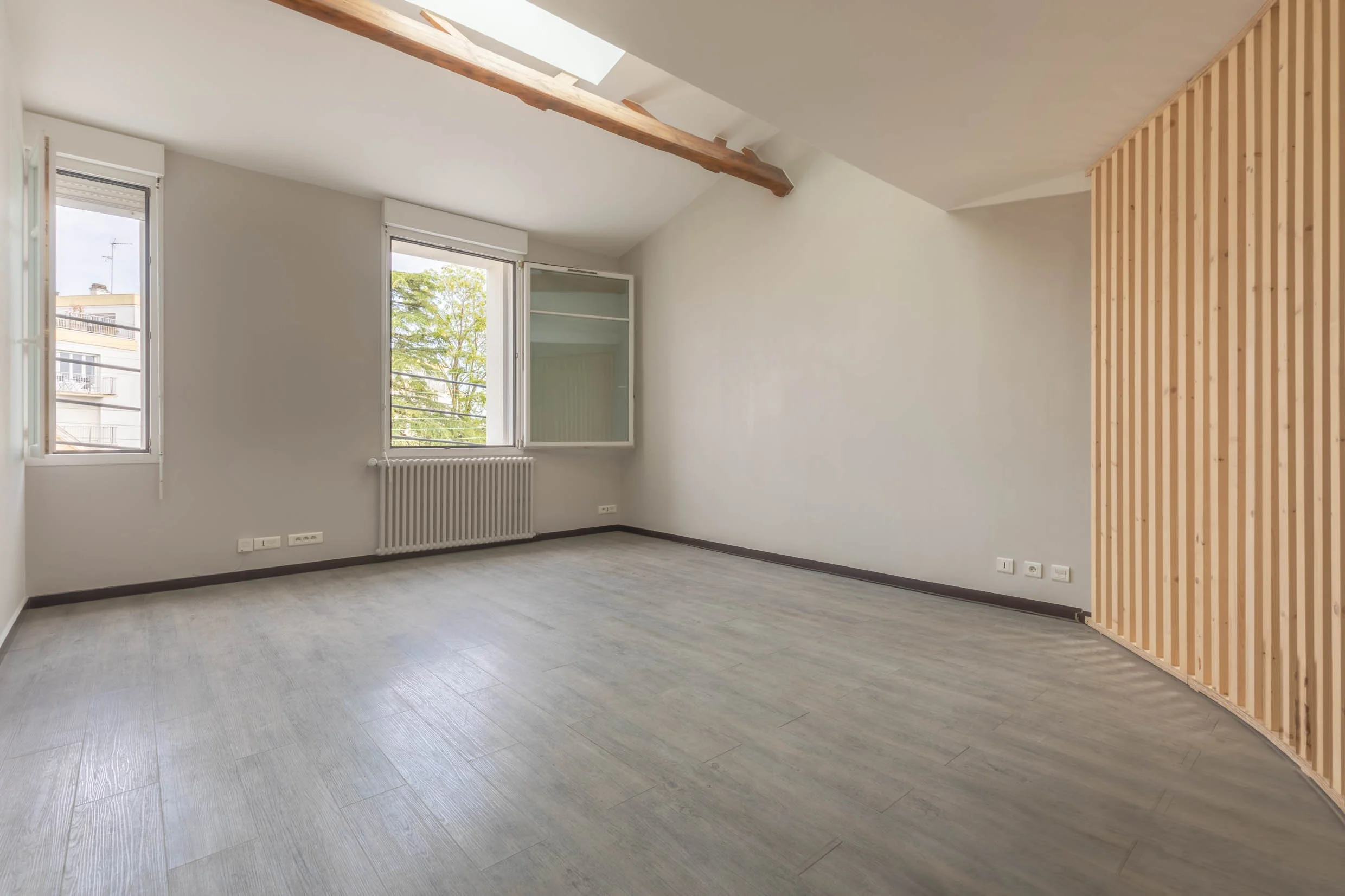 Salon vide photo immobilier nantes fenêtres apparentes et lumière naturelle poutre et bois présent pour mise en valeur du bien
