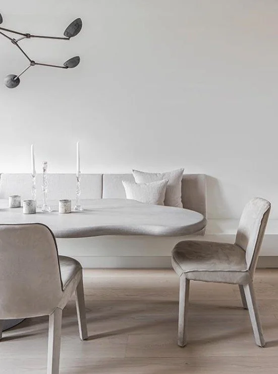 Salon avec table ronde, chaises en tissu beige, canapé blanc, chandelier moderne