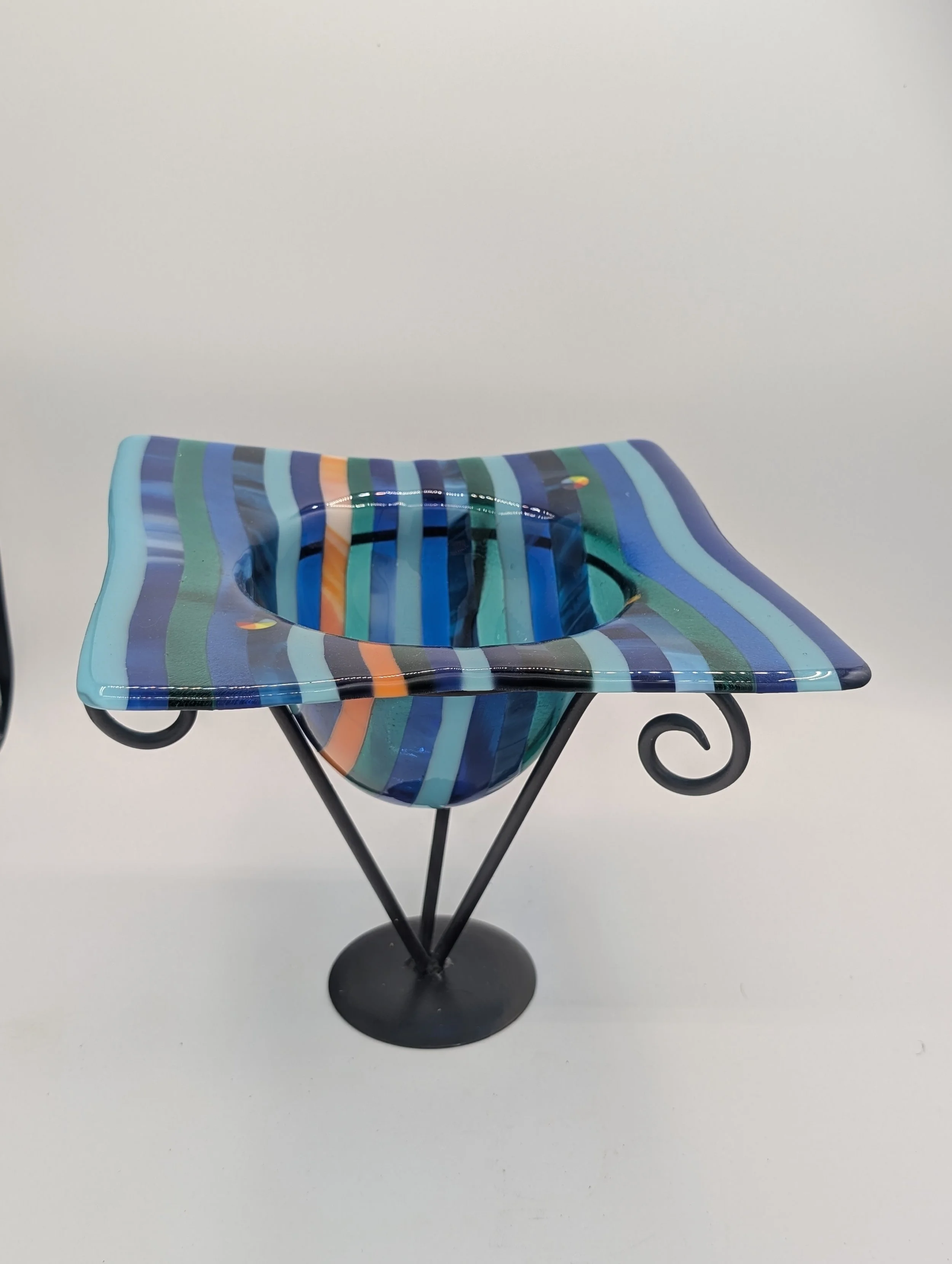 Ocean Ribbon fused glass vessel in navy, cobalt, turquoise and teal stripes on a black metal stand