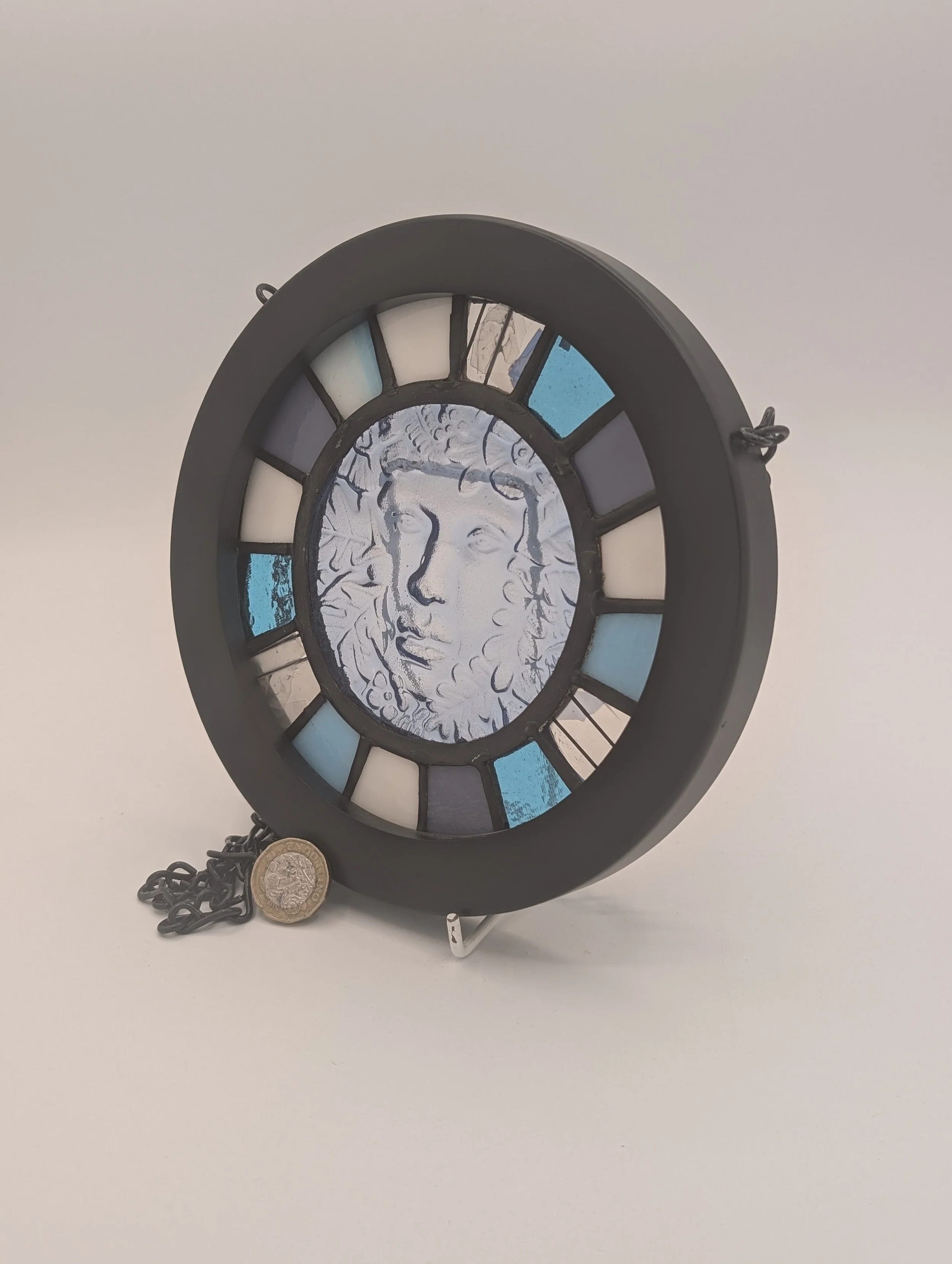 Angled view of Woodland Muse's textured icy blue leafy face and radial cyan, lavender and cream panes