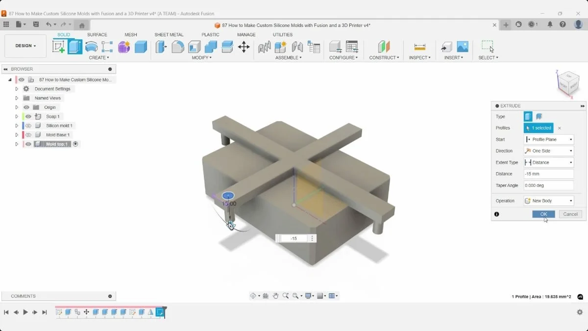 Fusion previews the second alignment-pin extrusion at −15 mm beneath the cross-shaped mold top.