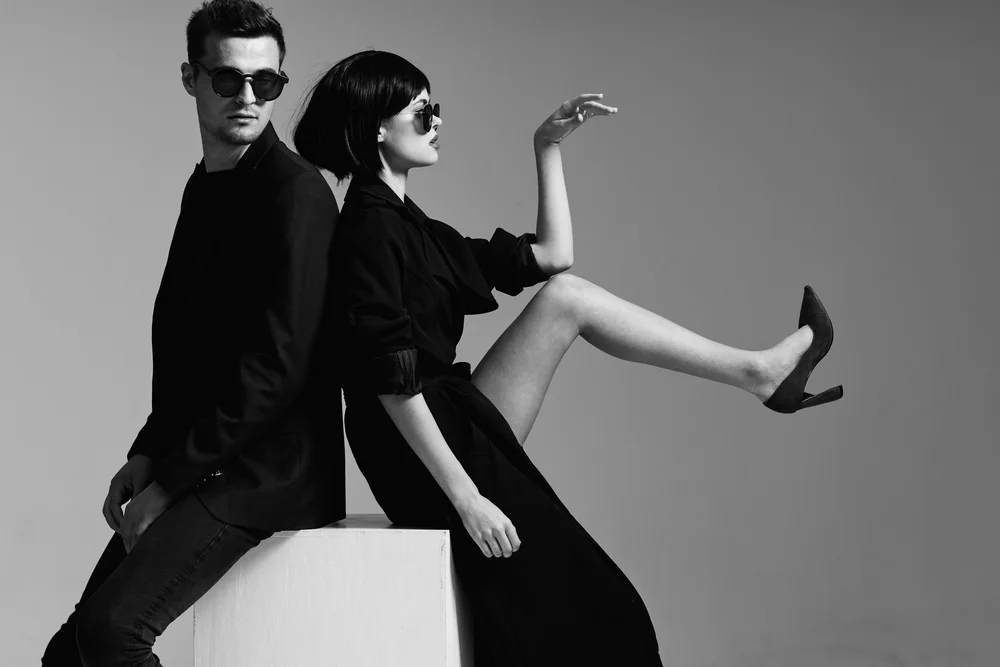 Official STELLA MGMT Editorial Duo - High-fashion minimalist studio session featuring male and female talent. Professional black and white commercial styling for Australian creative campaigns. Represented by Navun Pty Ltd