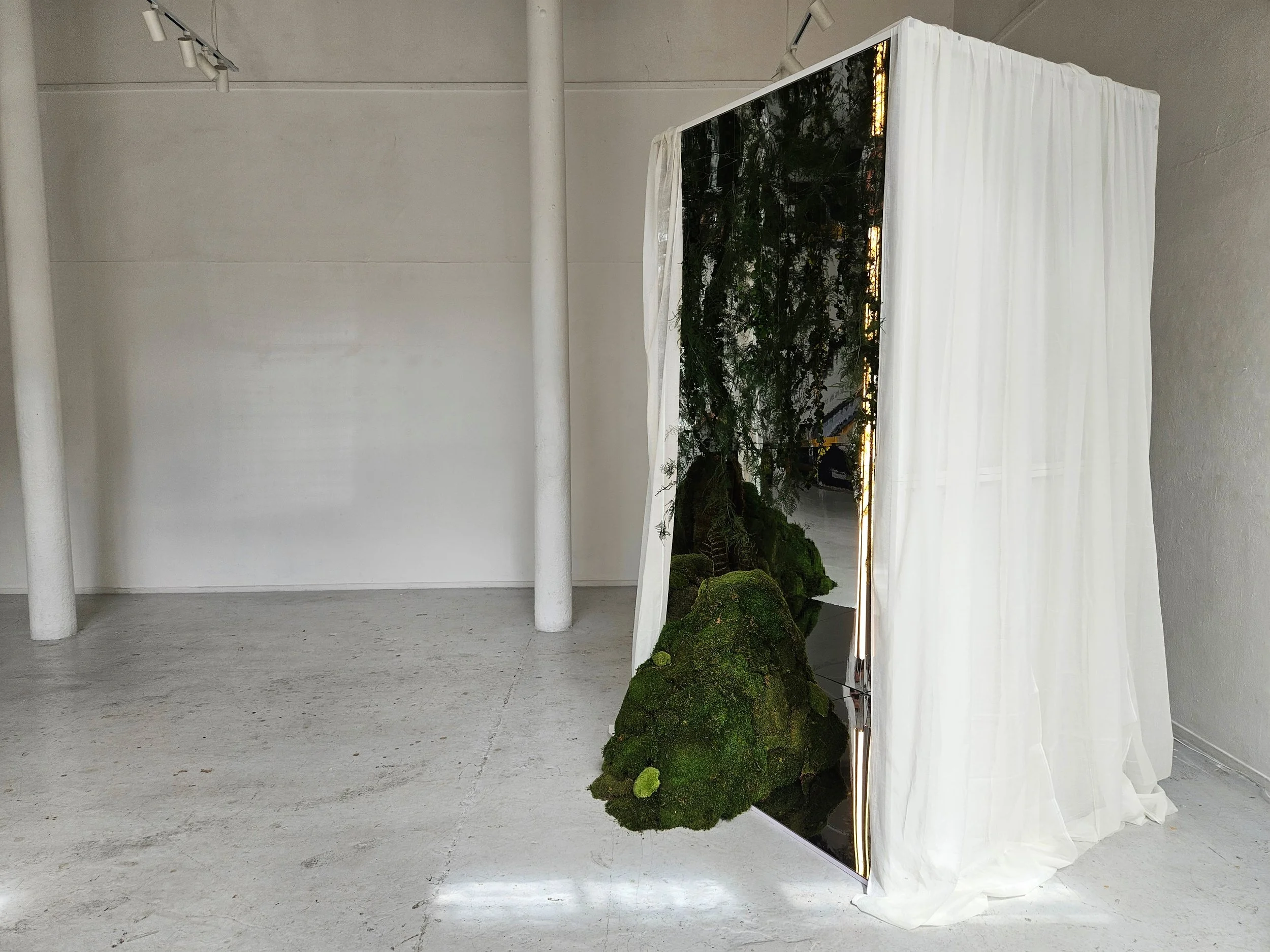 Botanical installation with moss, mirrored surfaces and fabric by Nàdair Studio