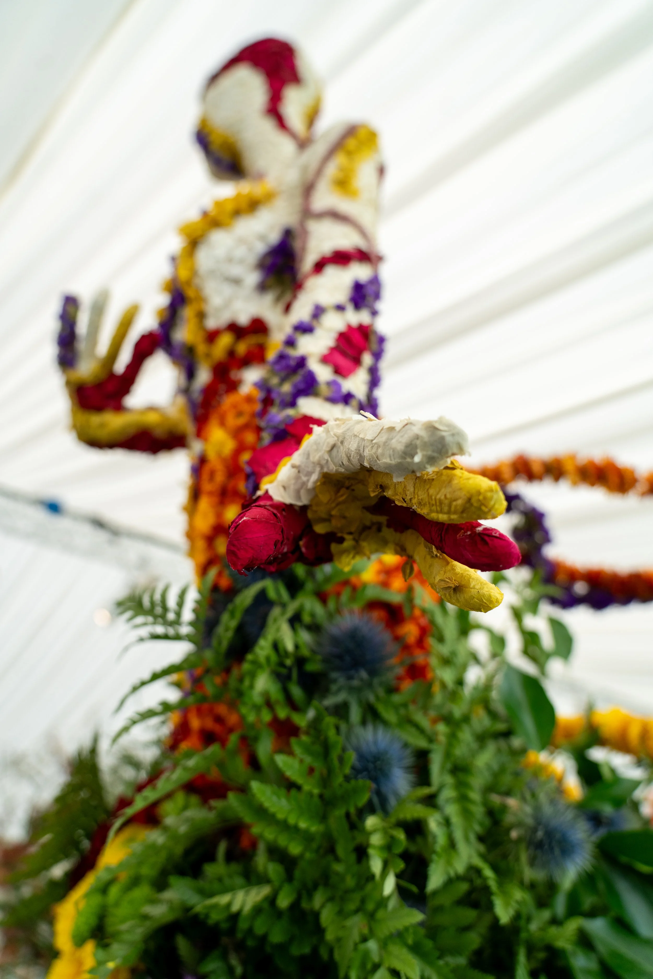 Close-up detail of floral installation showing hand sculpted with dried and preserved flowers, highlighting texture and colour layering