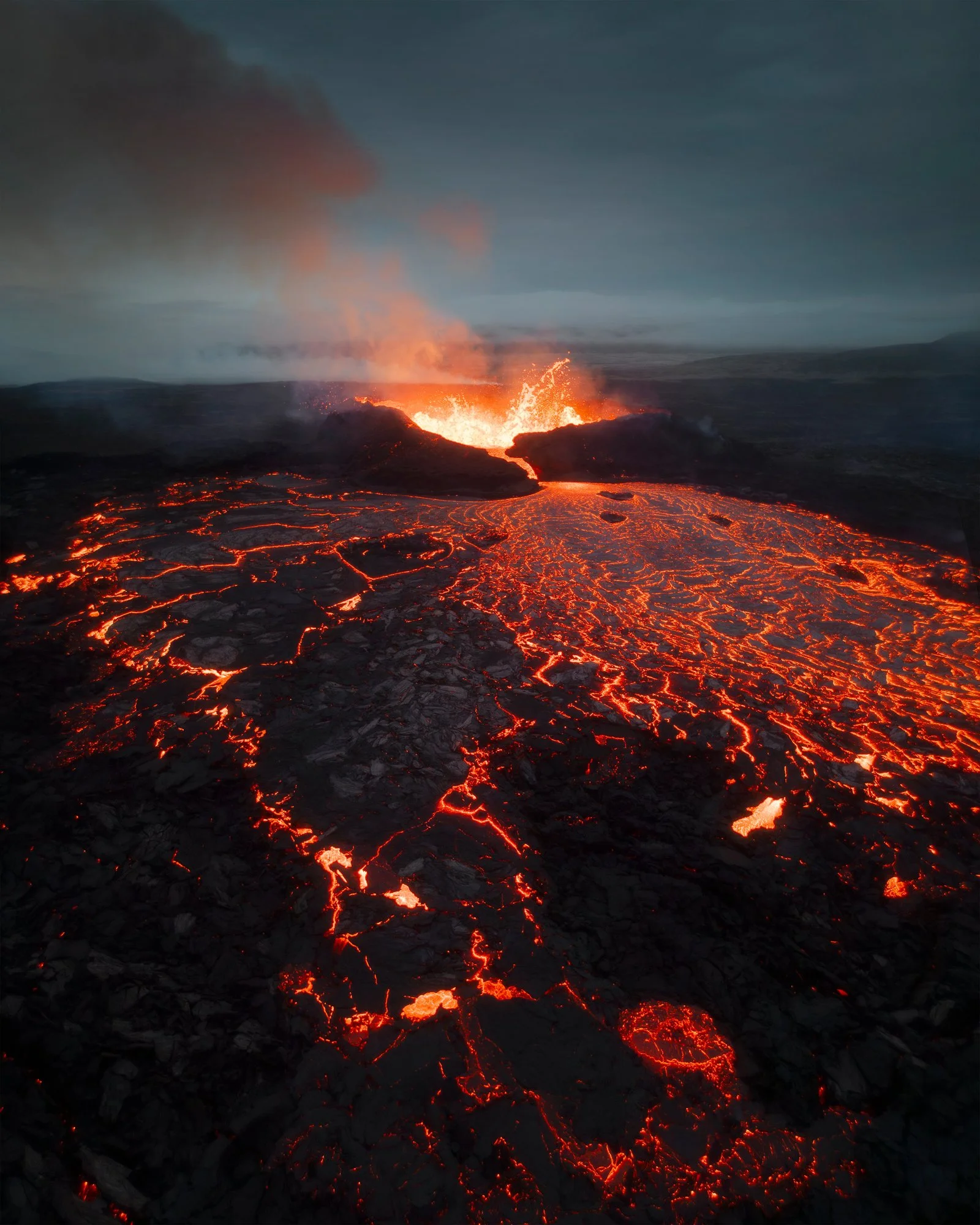 A mesmerizing aerial view of Fagradalsfjall volcano in Iceland, capturing the intense red glow of molten lava as it flows across the dark, rugged landscape. The photo is part of a three-image panoramic composition, meticulously stitched and manually 