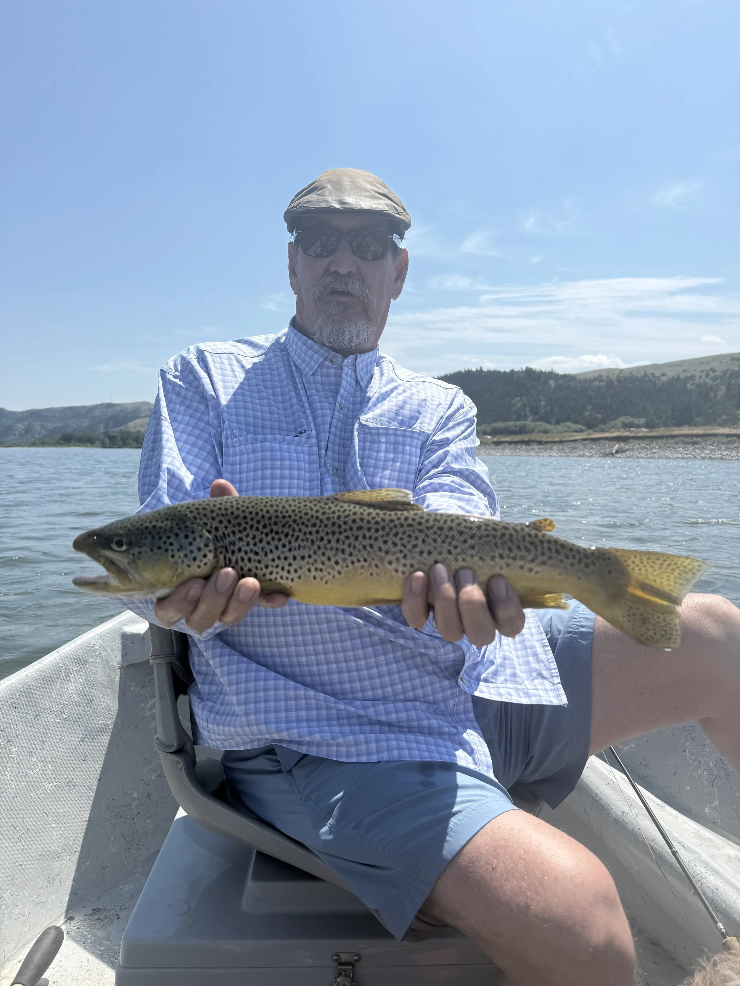 Angler holding large brown trout during guided fly fishing trip in Bozeman Montana