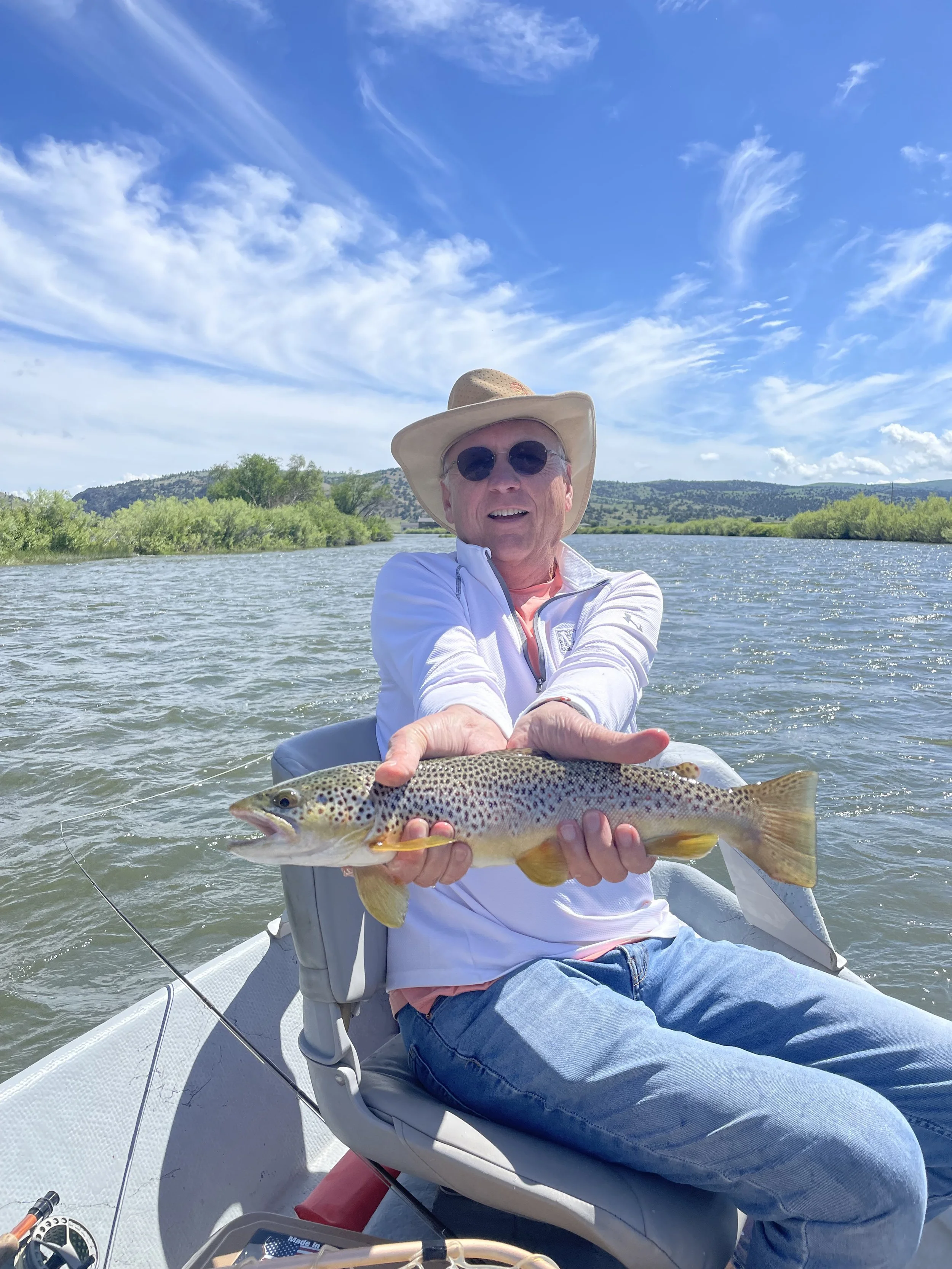 Client holding a nice brown trout caught on the lower Madison River on a guided fly fishing trip