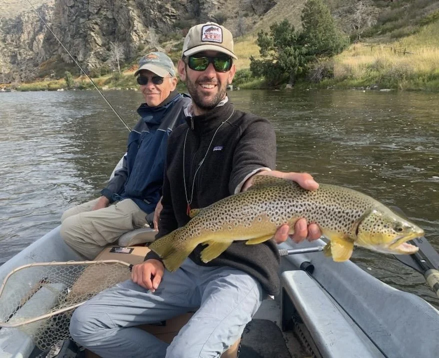 Guide holding a brown trout that a client caught on the lower Madison River