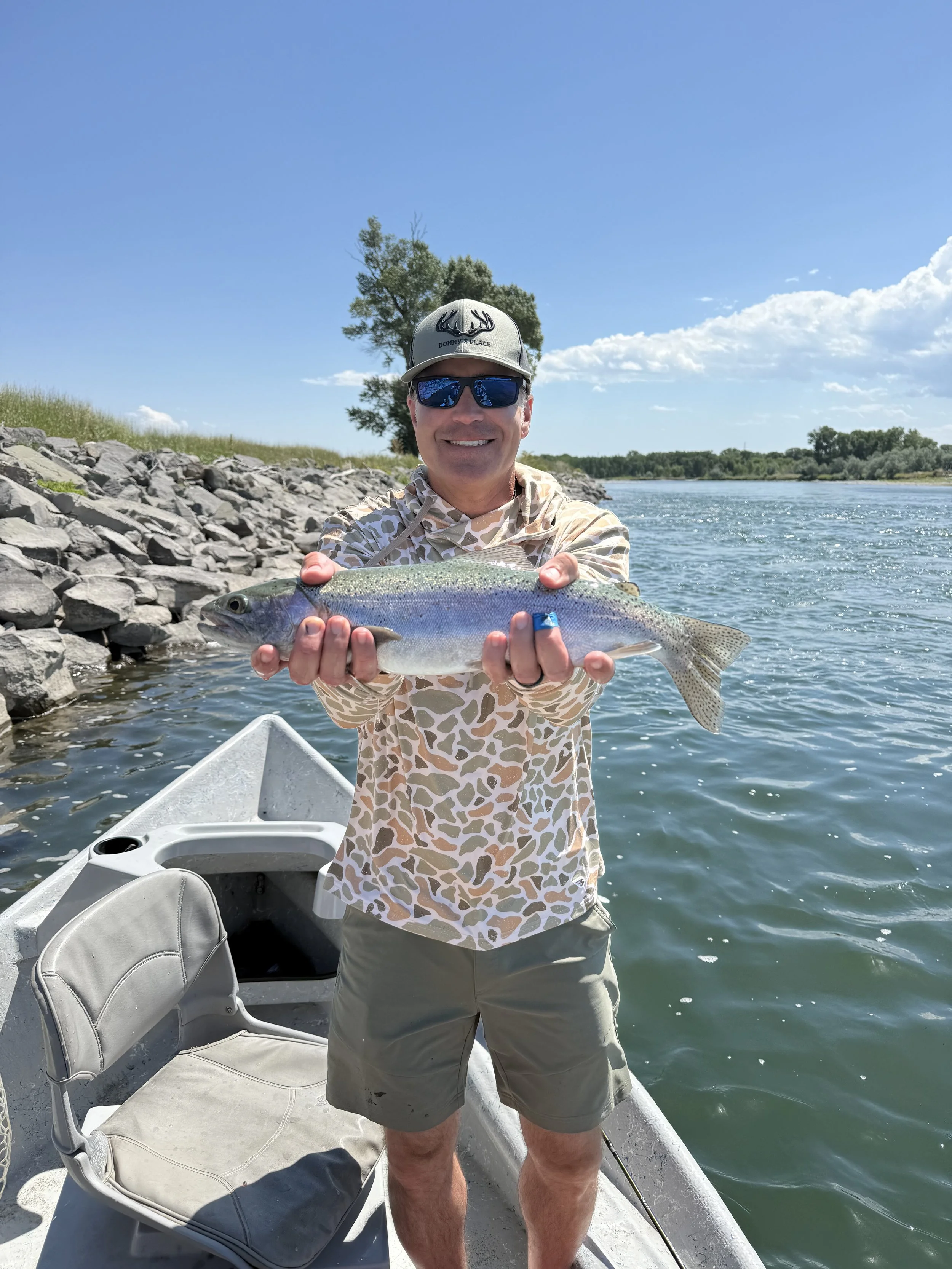 Client smiling with rainbow trout caught on Montana fly fishing trip