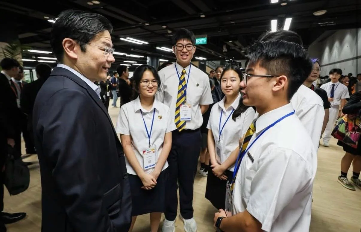 Jerome Ong speaking with Prime Minister Lawrence Wong among students at the SGLaw 200 Youth Forum.