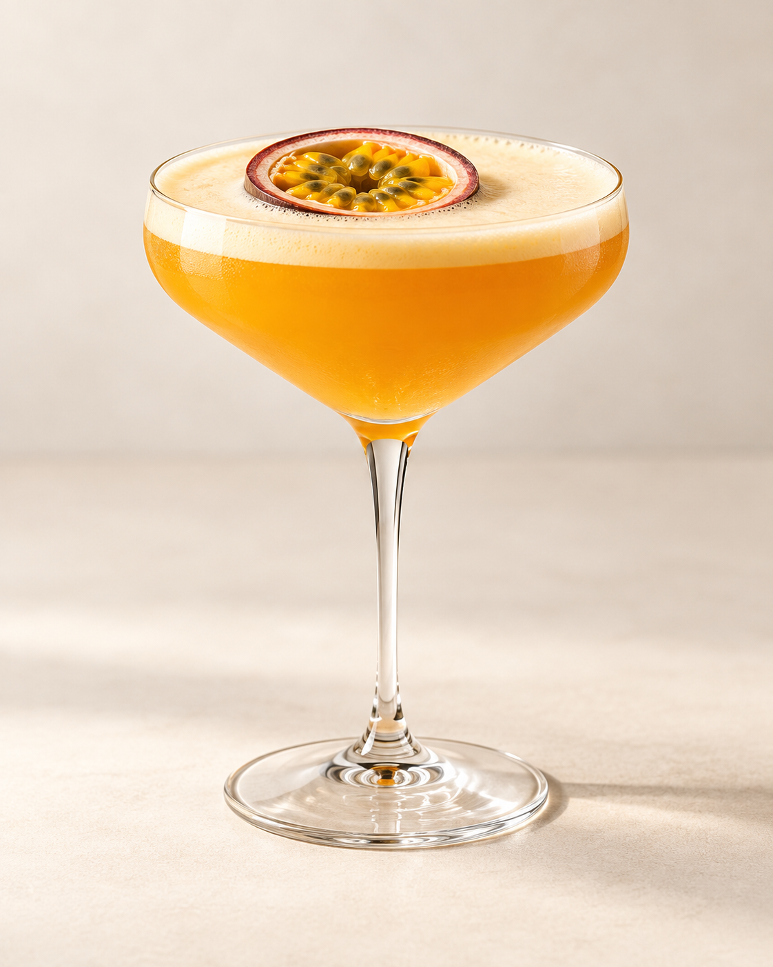 Passion fruit cocktail in a coupe glass garnished with passion fruit.