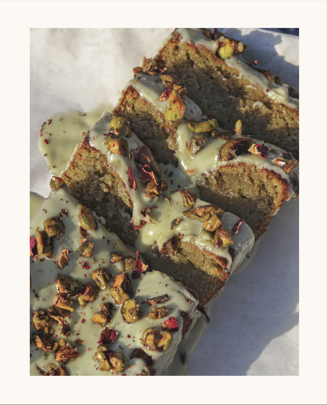 Pistachio rose loaf cake topped with a pistachio butter glaze