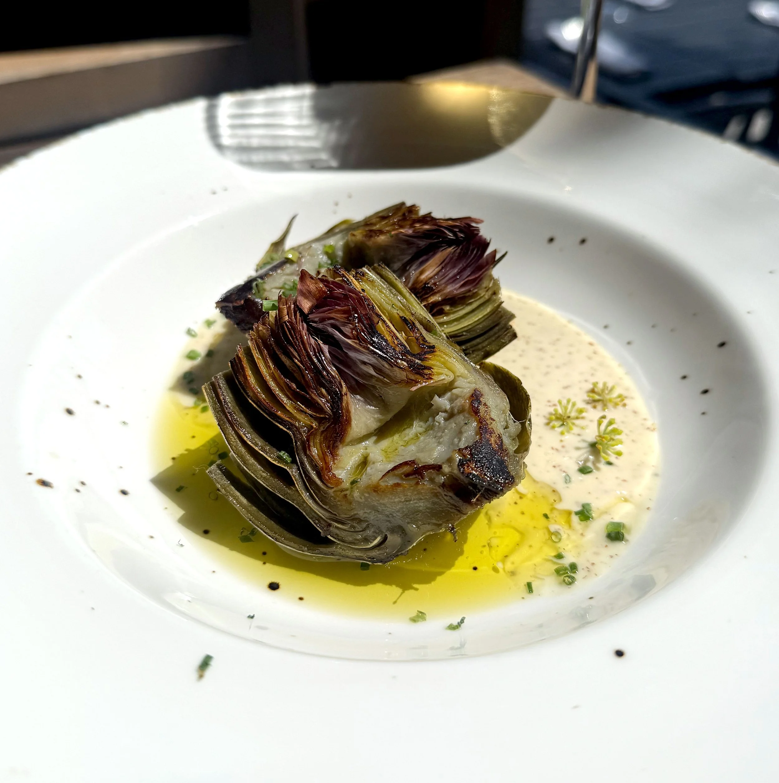 Spring artichoke steamed with lemon and herbs, served with garlic aioli for happy hour at Restaurant Terratorry
