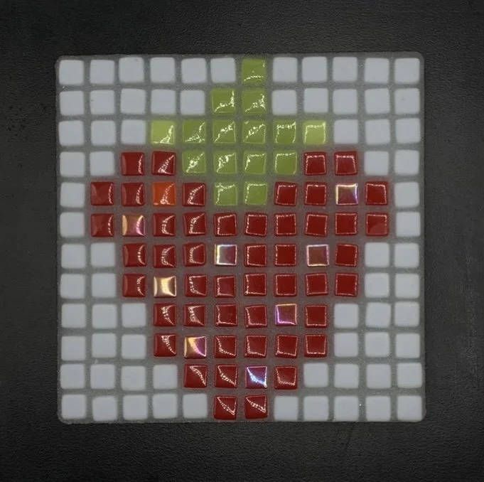 A mosaic of a raspberry with a green leaf on a light blue grid background.