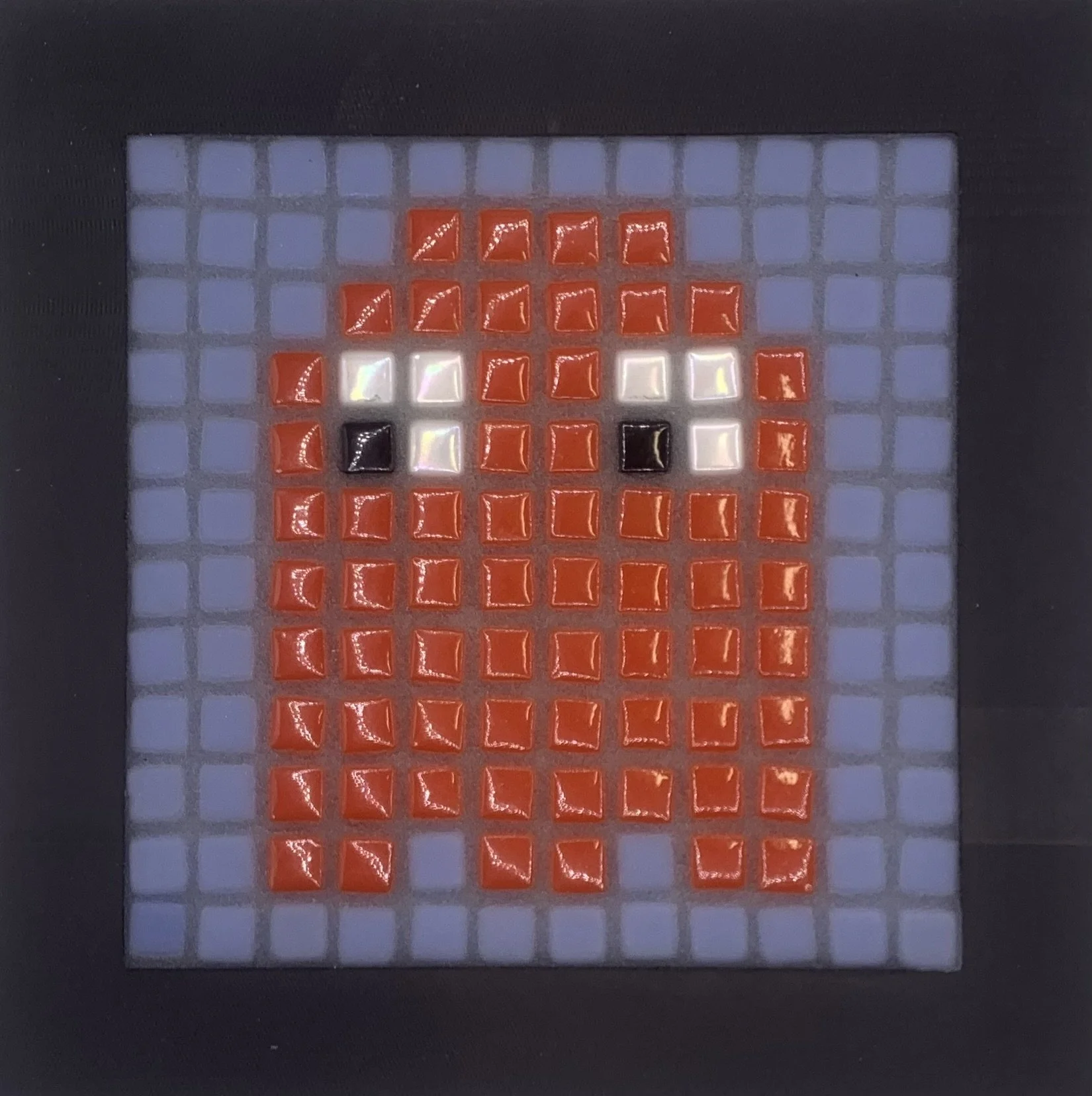 Pixel art of a cartoon pumpkin face on an electronic game screen.