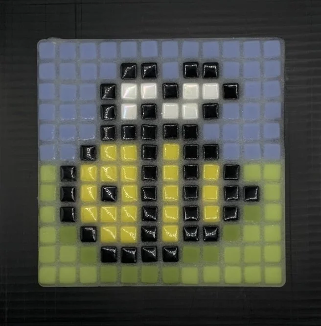 A mosaic of a bumblebee on green grass and blue sky in 8mm tiles.