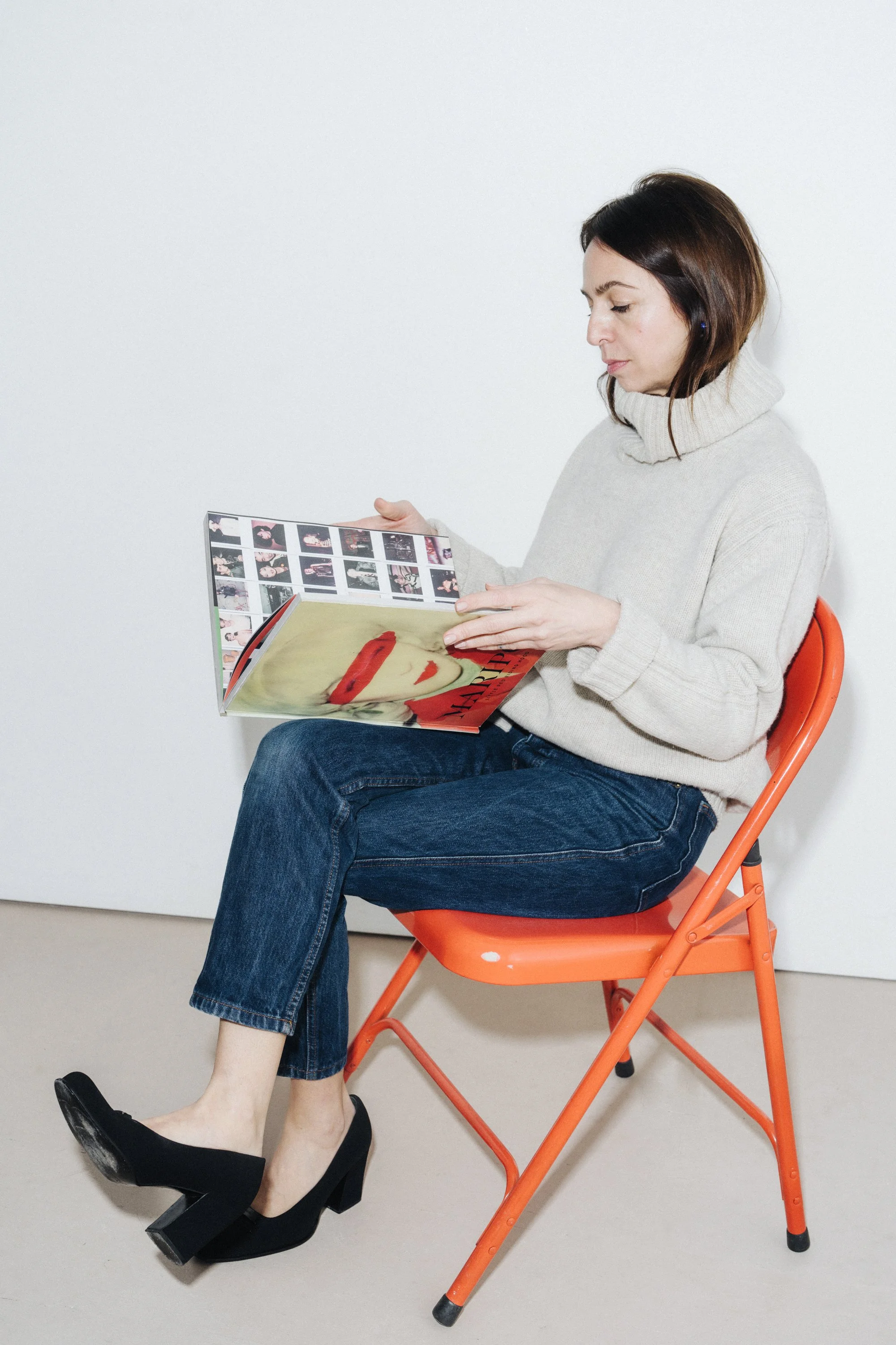 Home organizer arranging books and objects on living room shelves in London flat