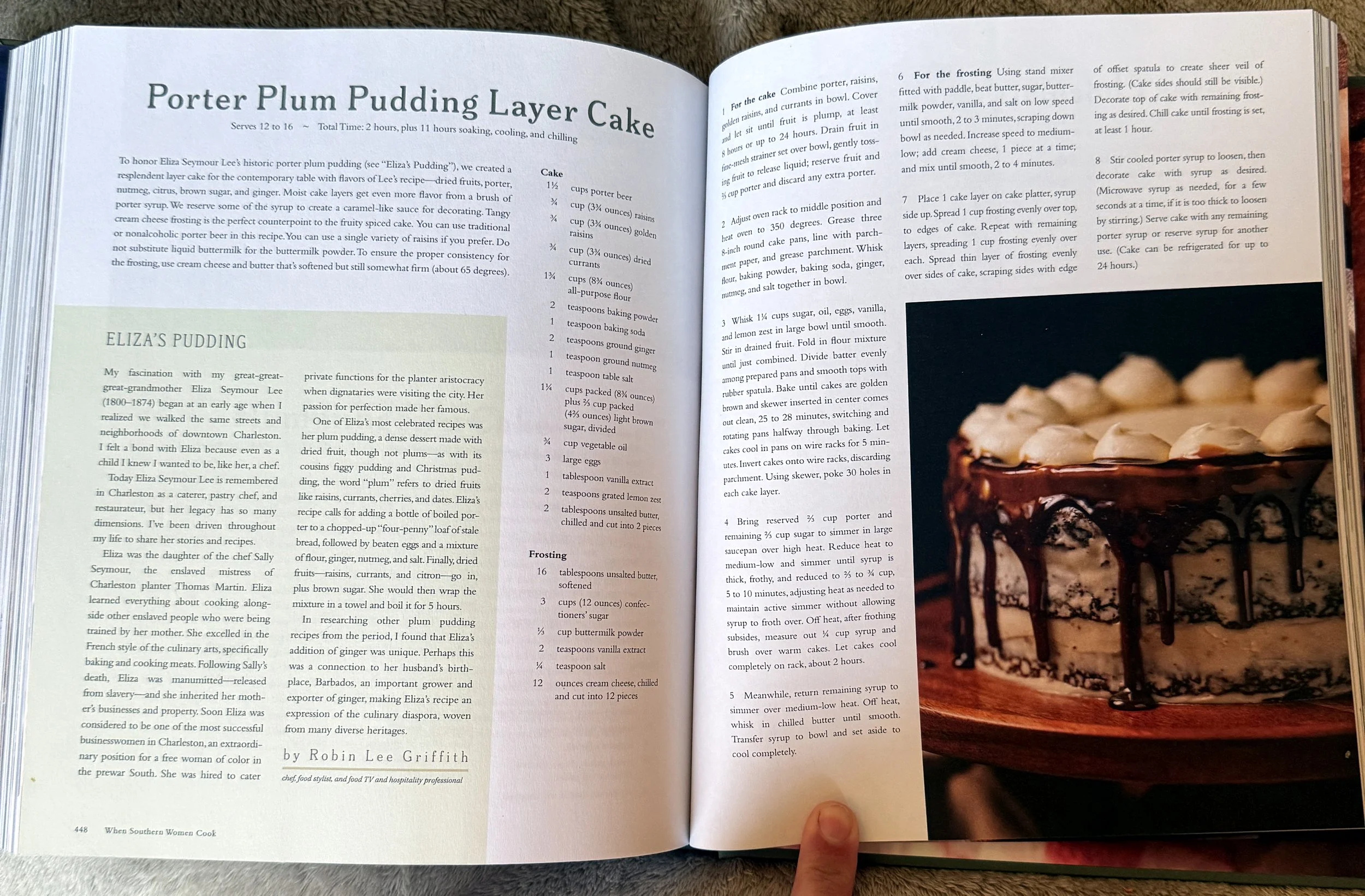 Open cookbook to a page titled 'Porter Plum Pudding Layer Cake' with ingredients and instructions, alongside a large photo of a multi-layered chocolate drizzle cake on the right side.