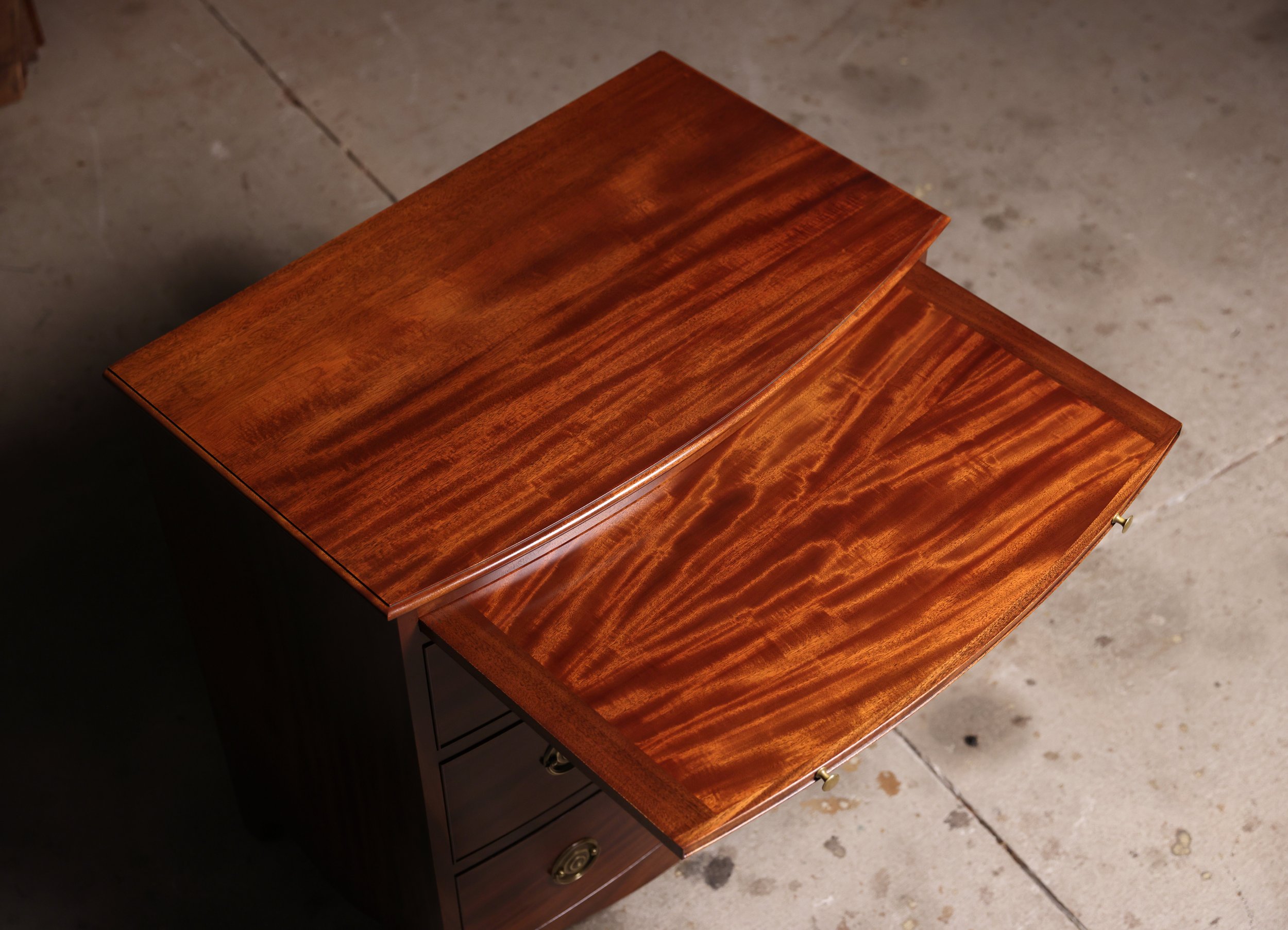 Handcrafted Bow Front Chest functional writing surface, also known as a brushing slide in England. Single wide board mahogany top, cut from same board as case sides.