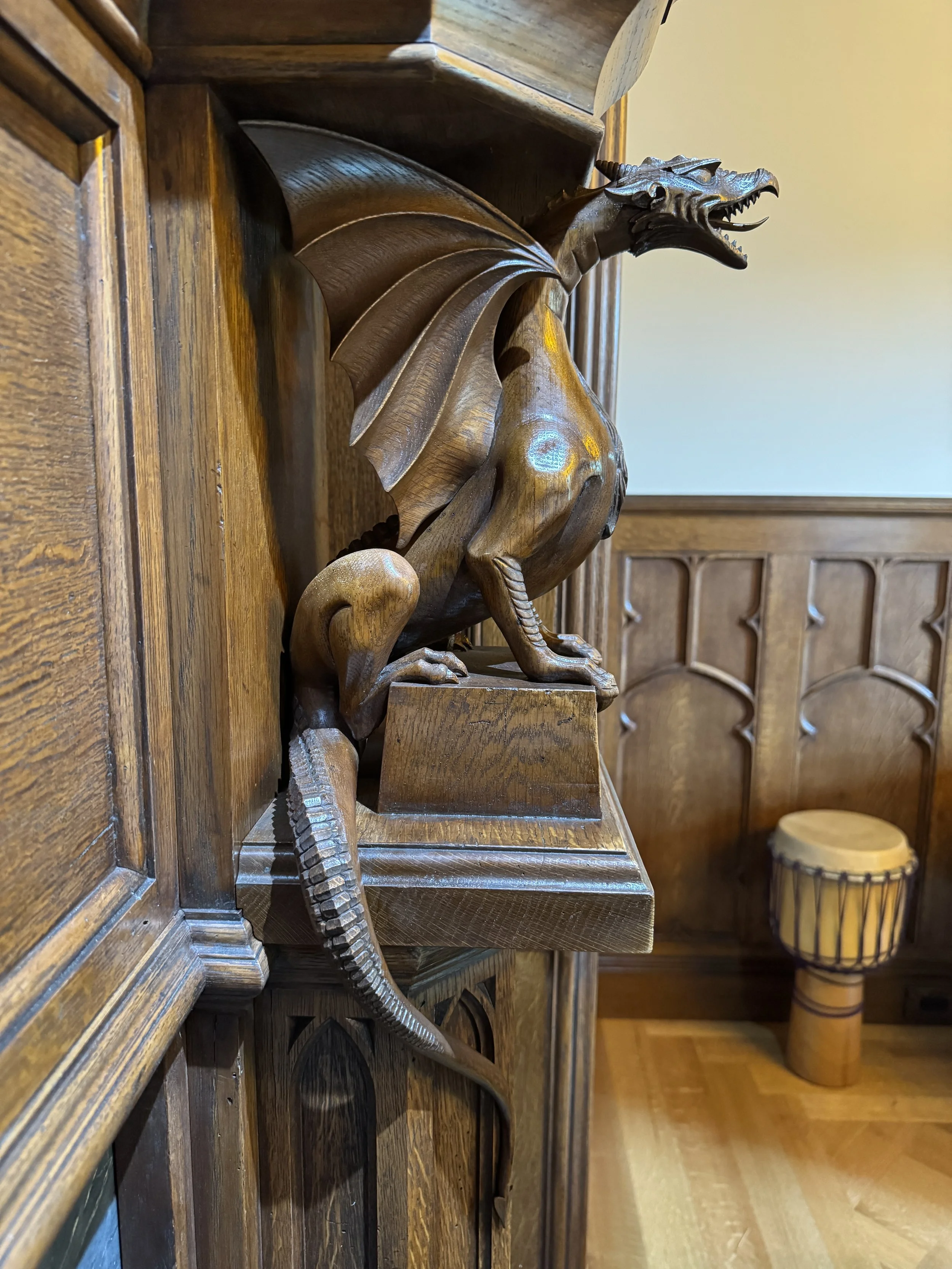 Close up of hand carved oak dragon, Gothic style fireplace decoration, detailed architectural wood carving.