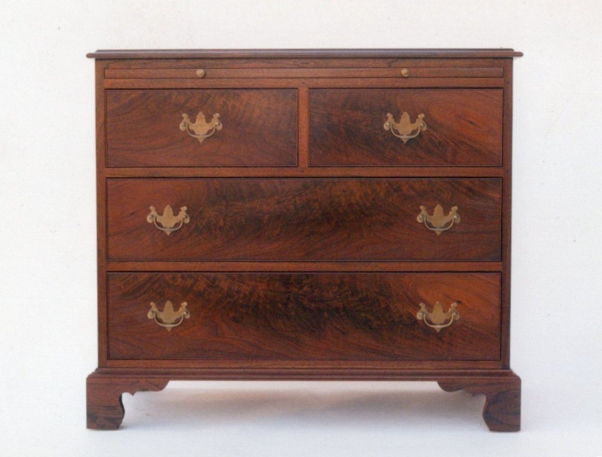 Handmade low chest with writing surface in walnut and crotch walnut.