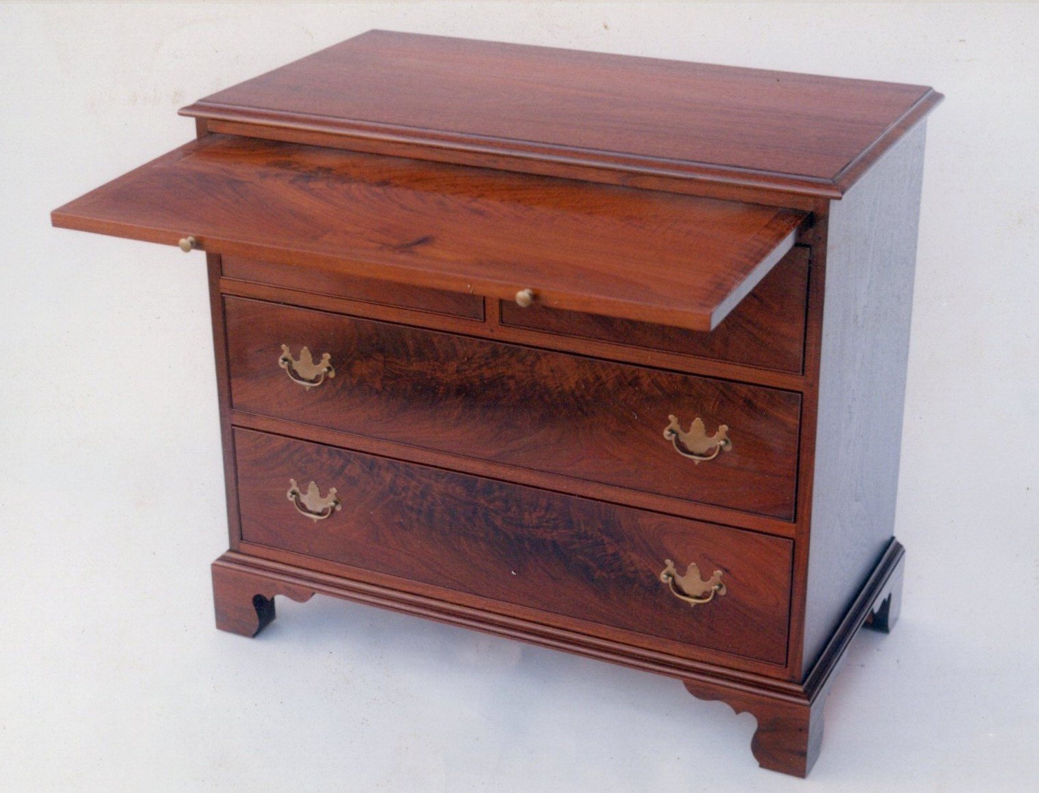 Hand crafted bachelors/low chest with writing surface/brushing slide in walnut and crotch walnut.
