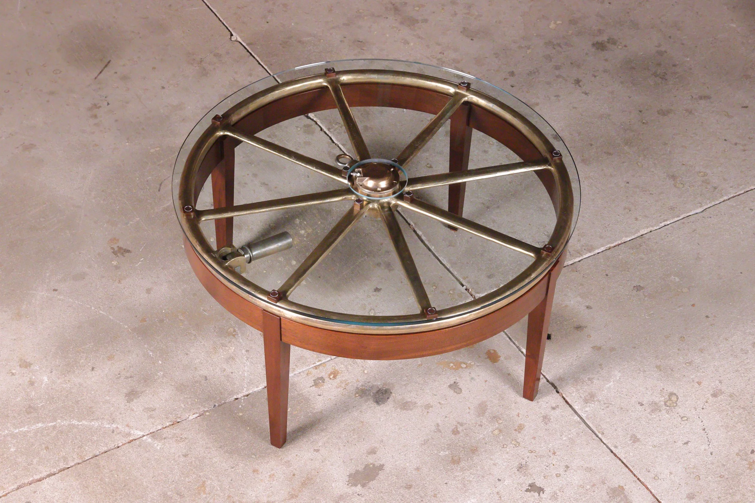 Solid walnut coffee table base, custom engineered to support an 80 pound World War II naval artifact wheel, hand rubbed shellac finish.